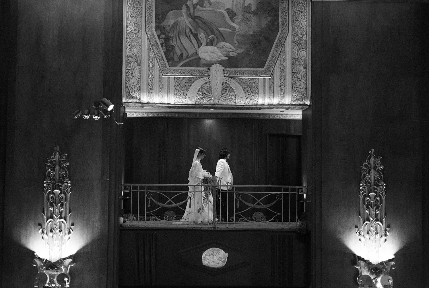 Bride and groom on a balcony during a Southern California wedding ceremony inside an ornate venue.