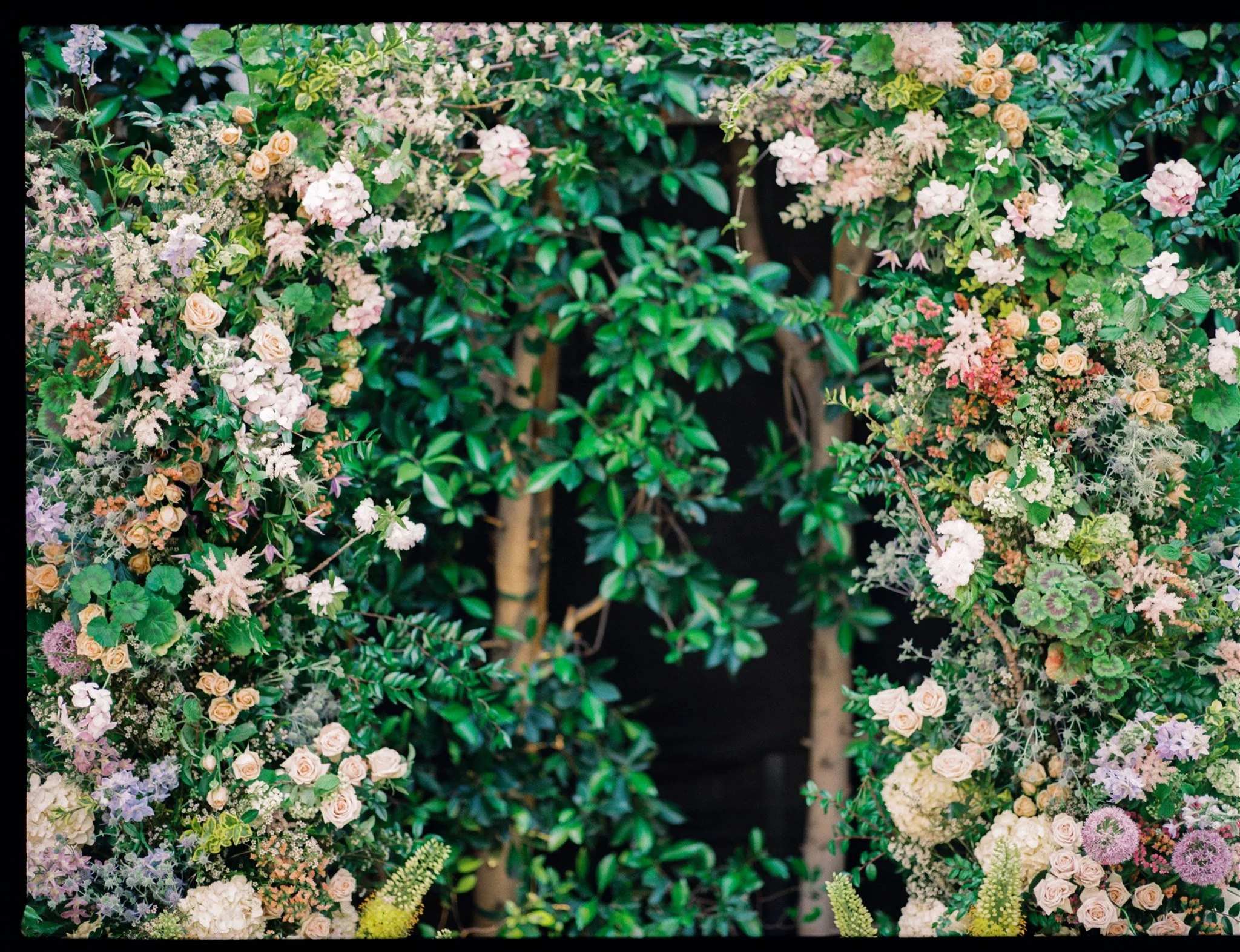 Garden-inspired floral backdrop at a Southern California restaurant wedding reception.