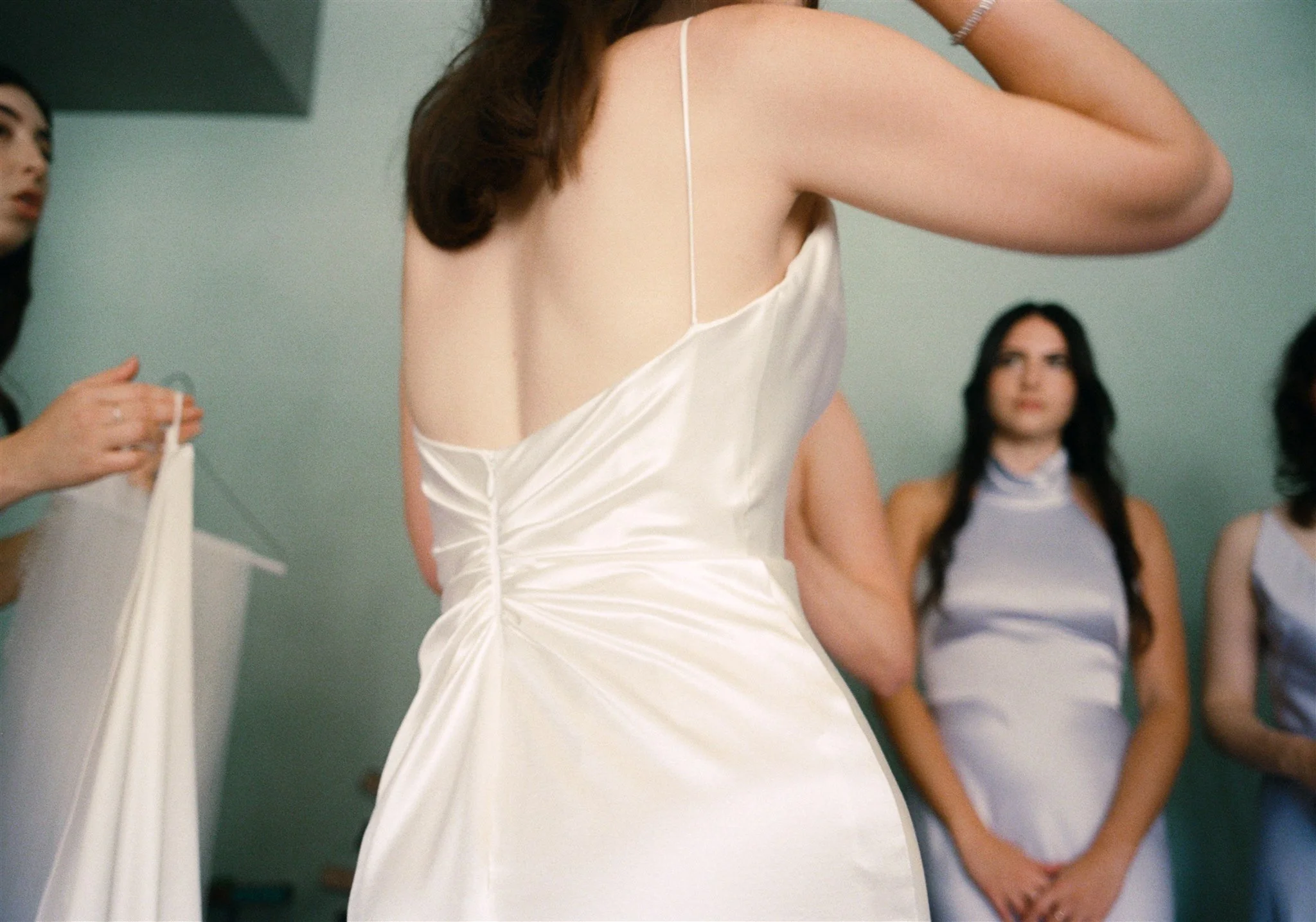 Bride getting ready in a satin gown before a Los Angeles restaurant wedding.