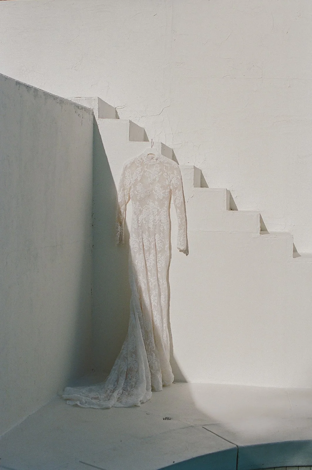 Bridal gown displayed in minimalist white wedding setting.