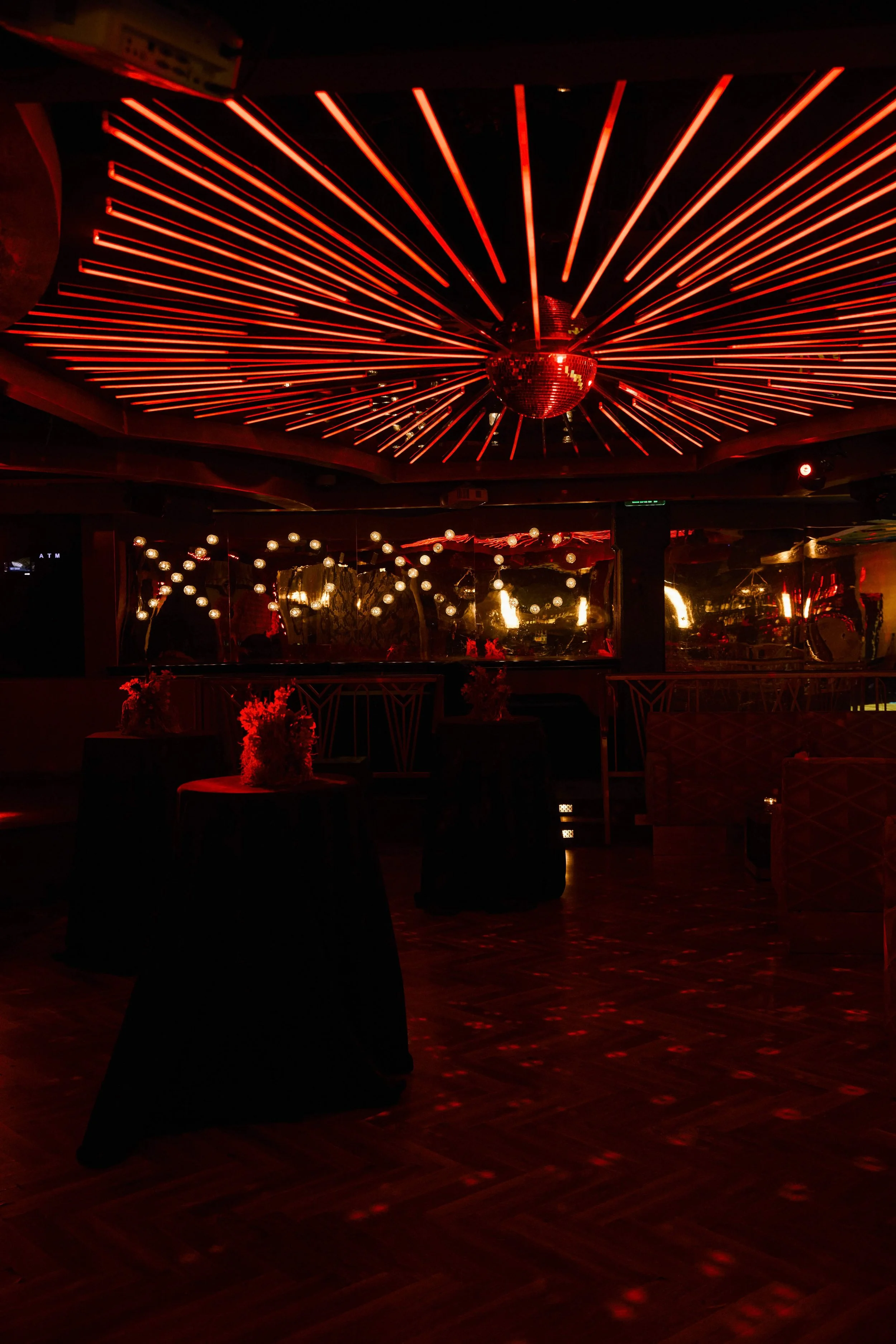 Moody red lighting design for a luxury celebrity event reception.