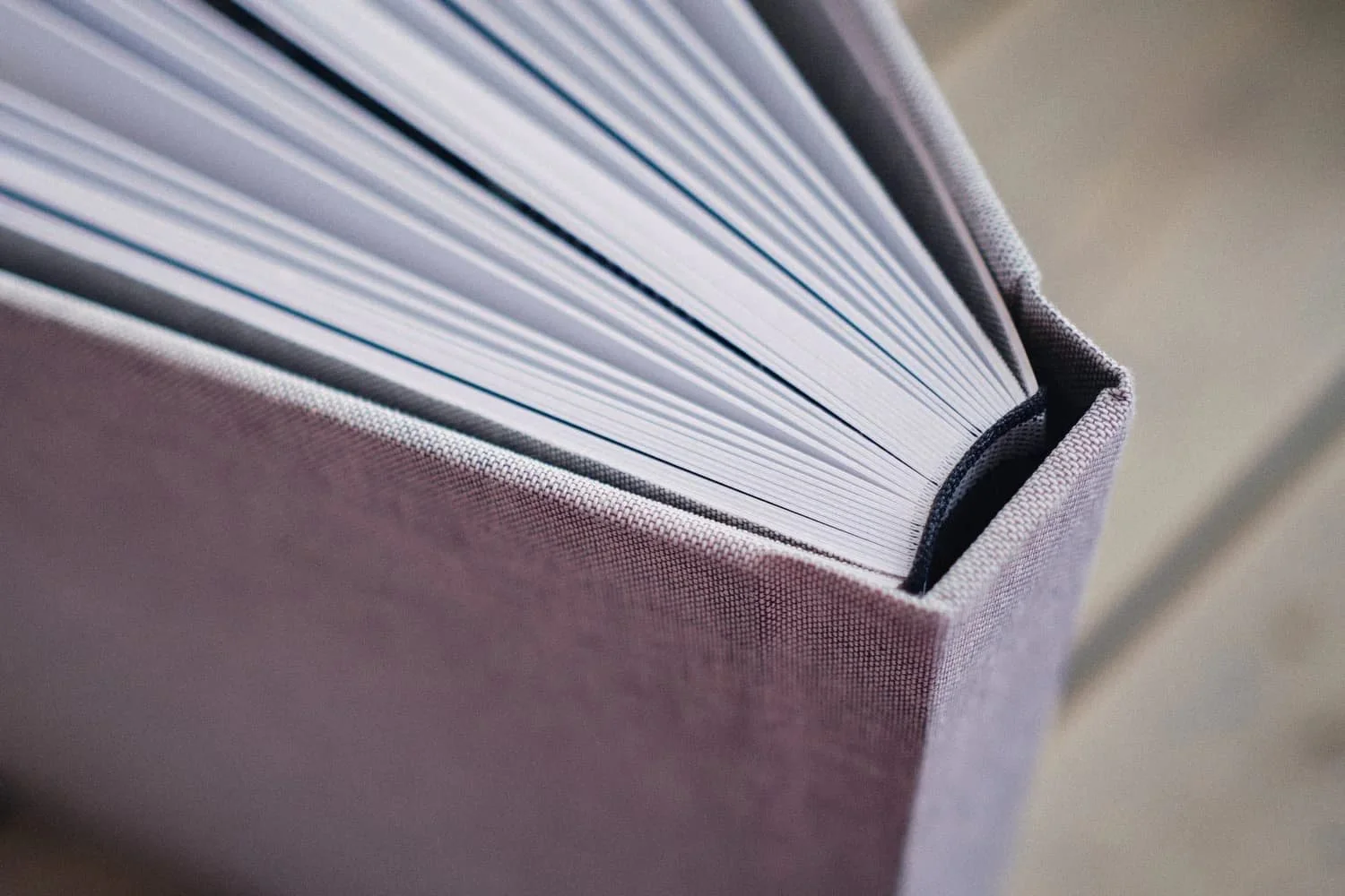 Een boek met witte pagina's in een grijze stoffen kaft.