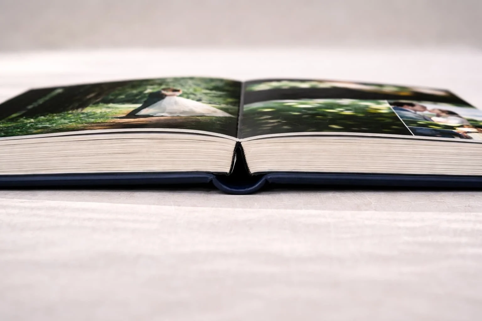 Open fotoboek met foto's van mensen, gelegen op een lichte tafel.