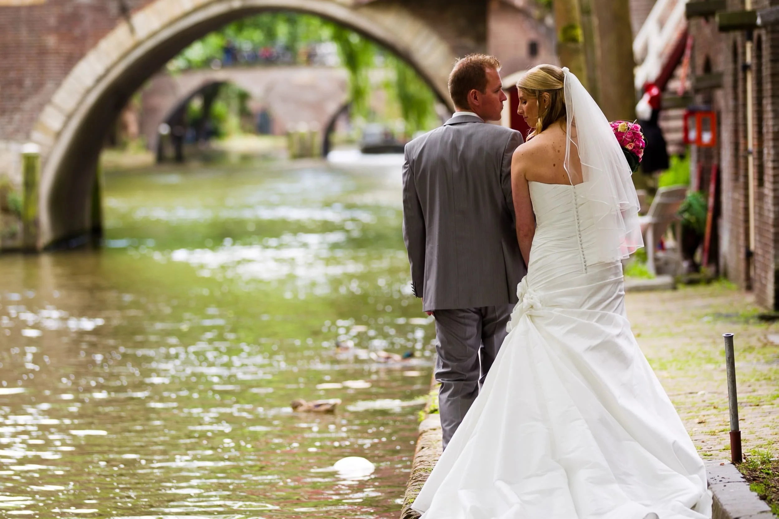 Bruidsfotografie langs de grachten van Utrecht met keldergewelven op de achtergrond