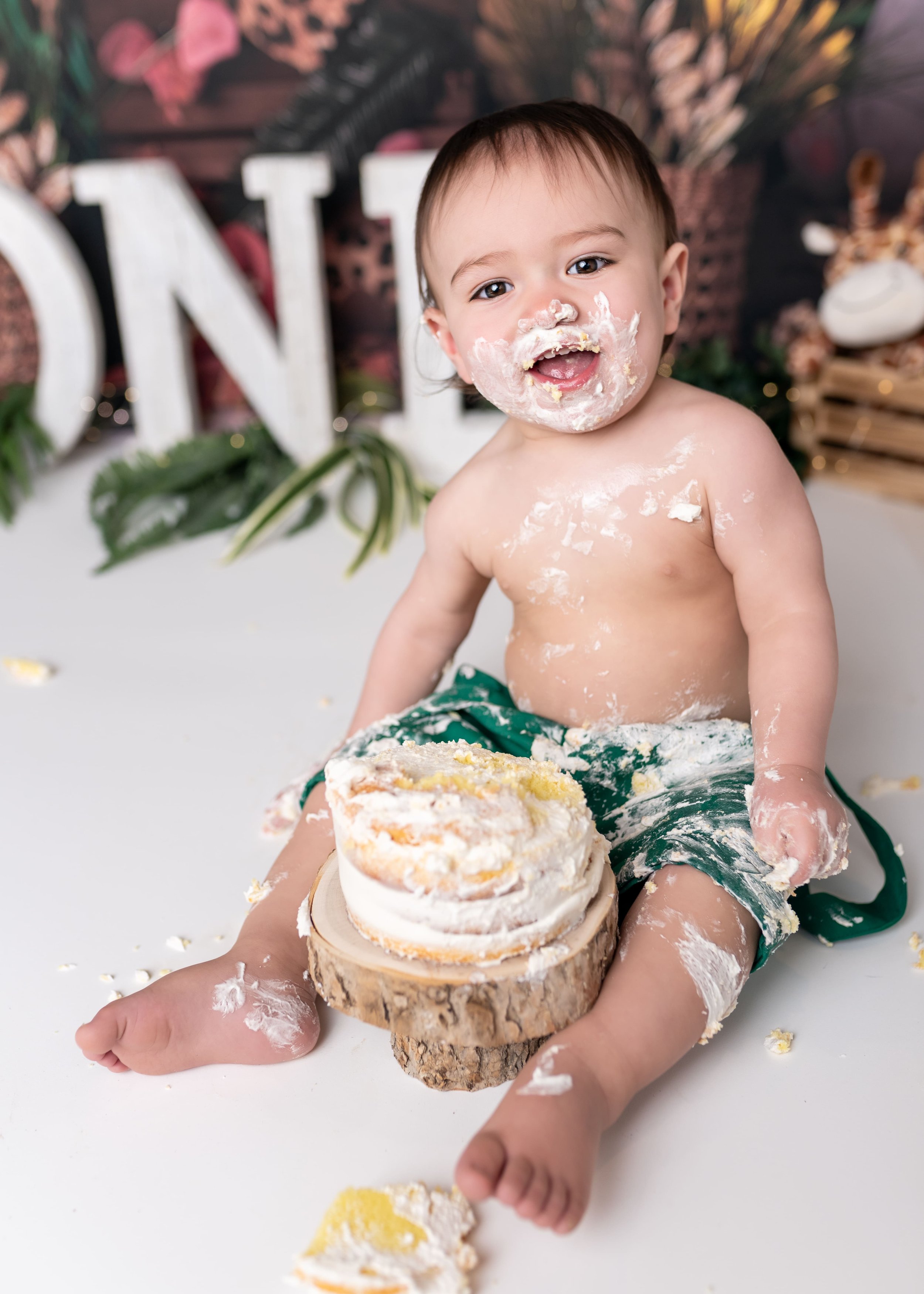 Sweet 1st birthday cake smash photography session in Canton, GA studio featuring baby boy with jungle theme