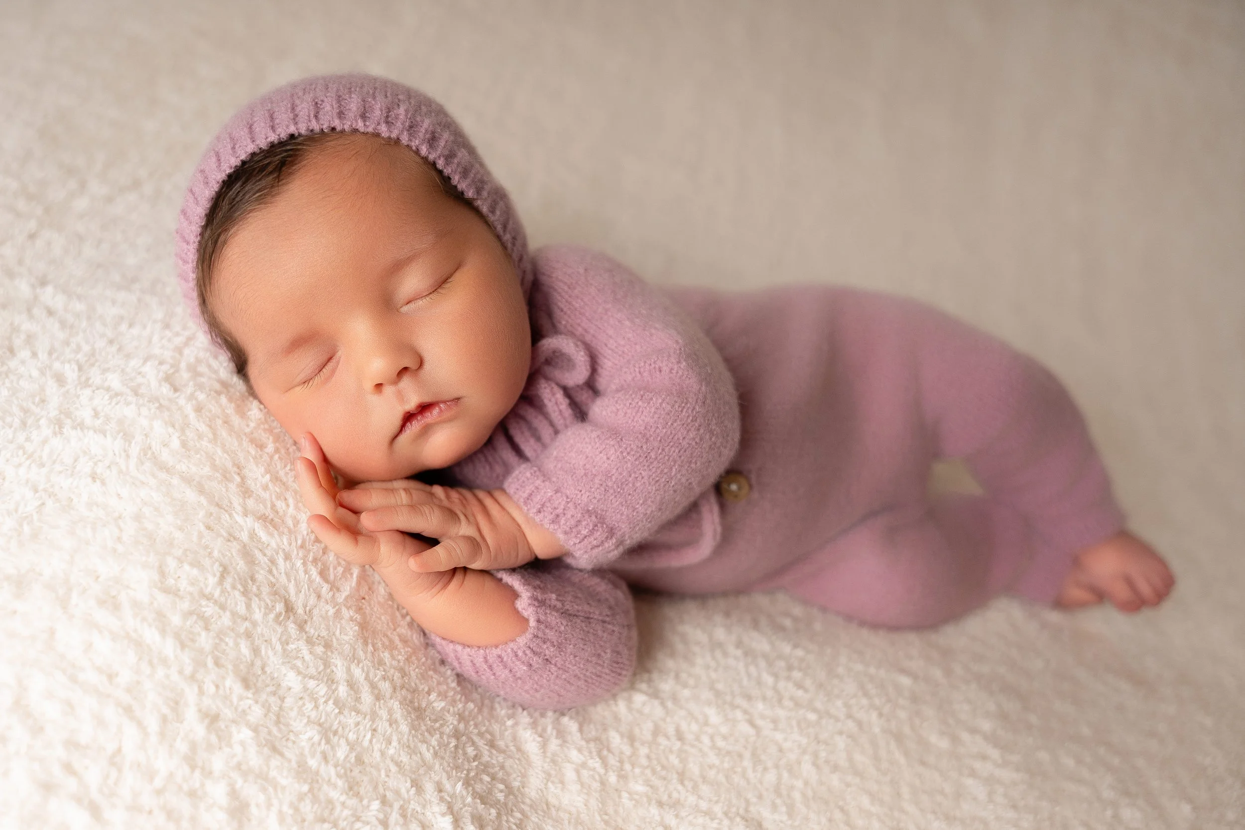 image of sleeping baby wearing a comfy fuzzy romper with matching bonnet