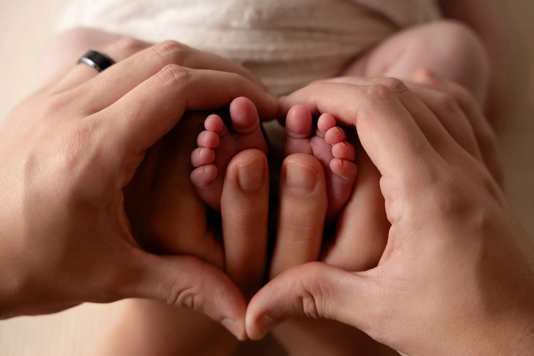 image of newborn toes with mom and dad's hands in photography studio in Canton GA