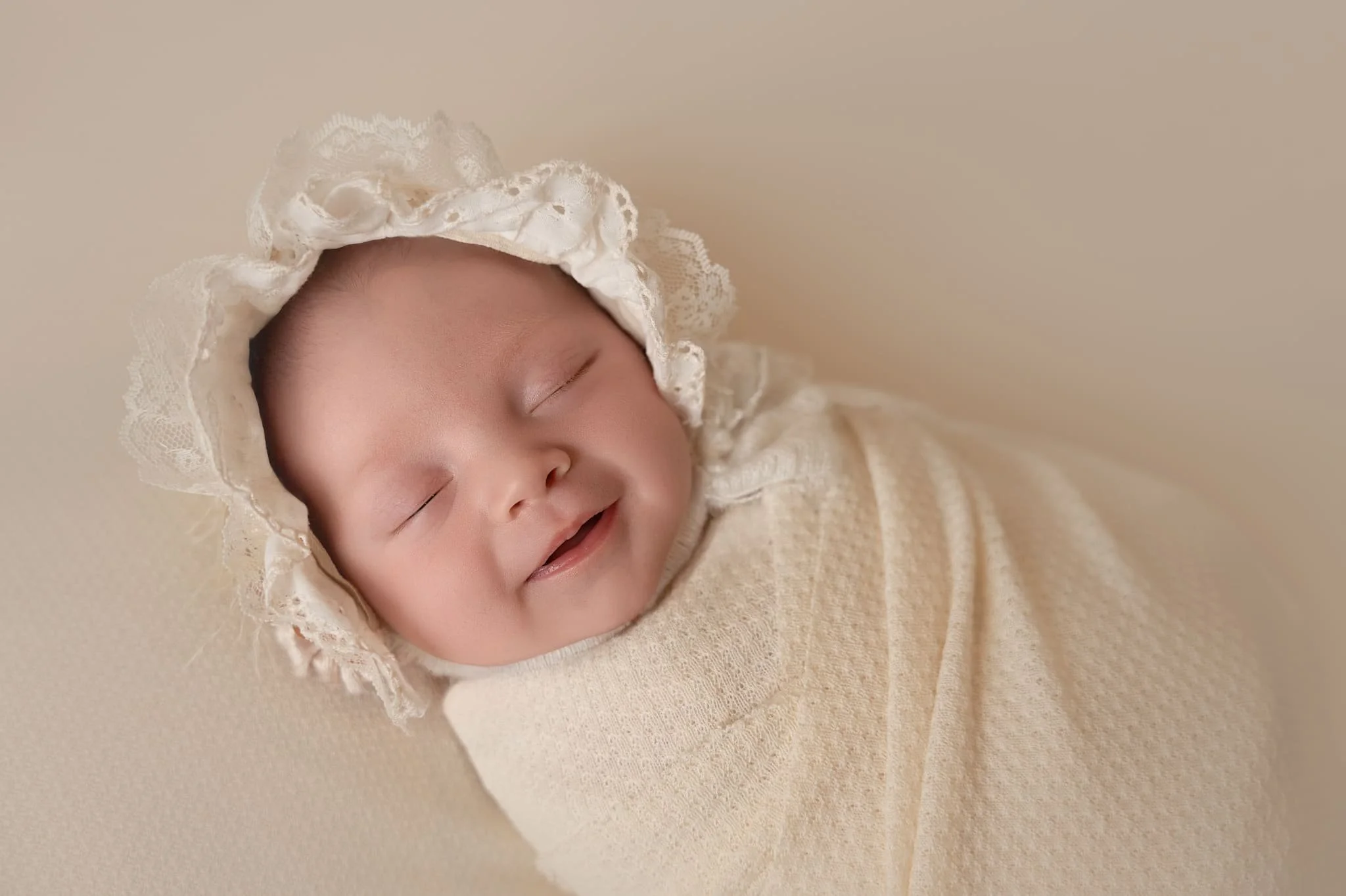 north ga newborn photographer's image of newborn baby girl wrapped and smiling for her studio newborn session