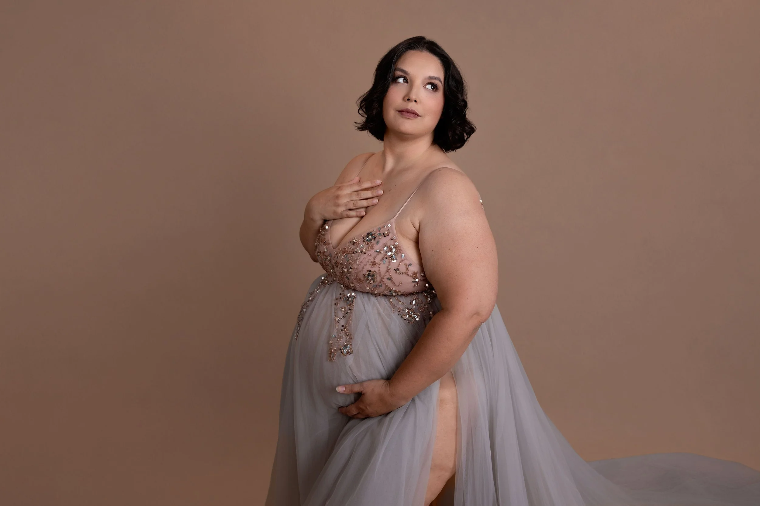 beautiful plus size pregnant woman posing in photography studio for maternity session with Captured Moments by Cindy