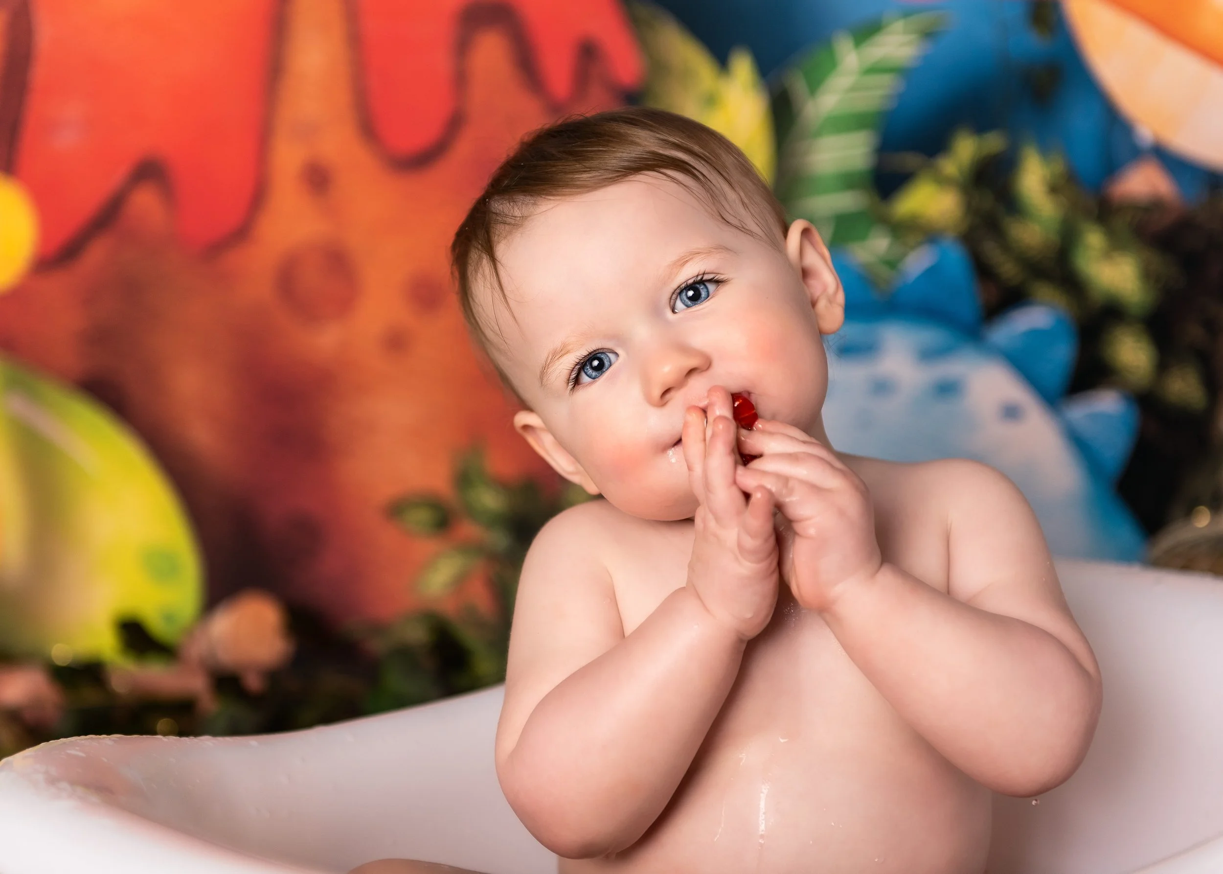 sweet baby posing for 1st birthday cake smash photography session in a studio setting