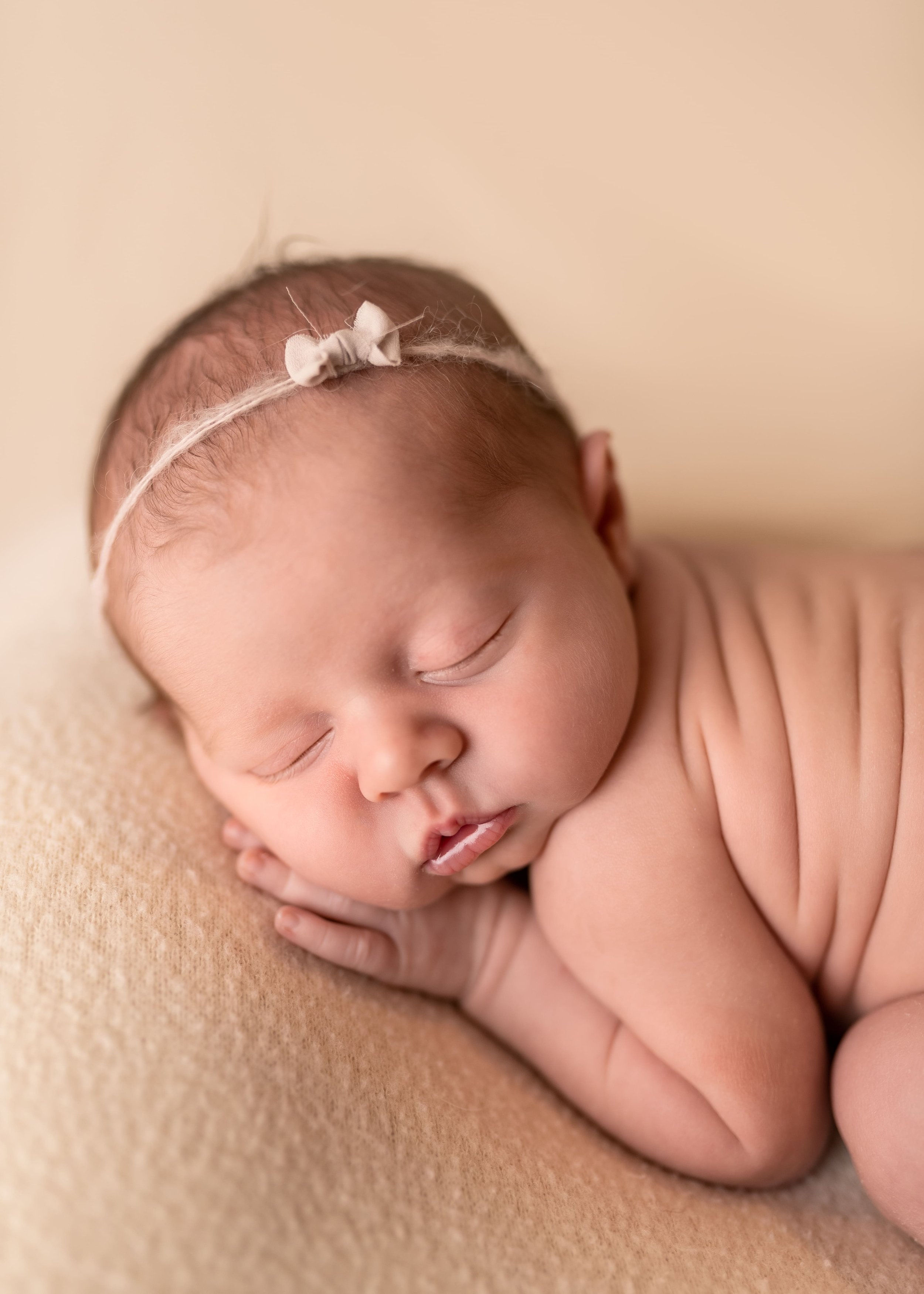 sweet baby photoshoot in Canton, GA showing a newborn baby posed on a comfy spot in bum up pose