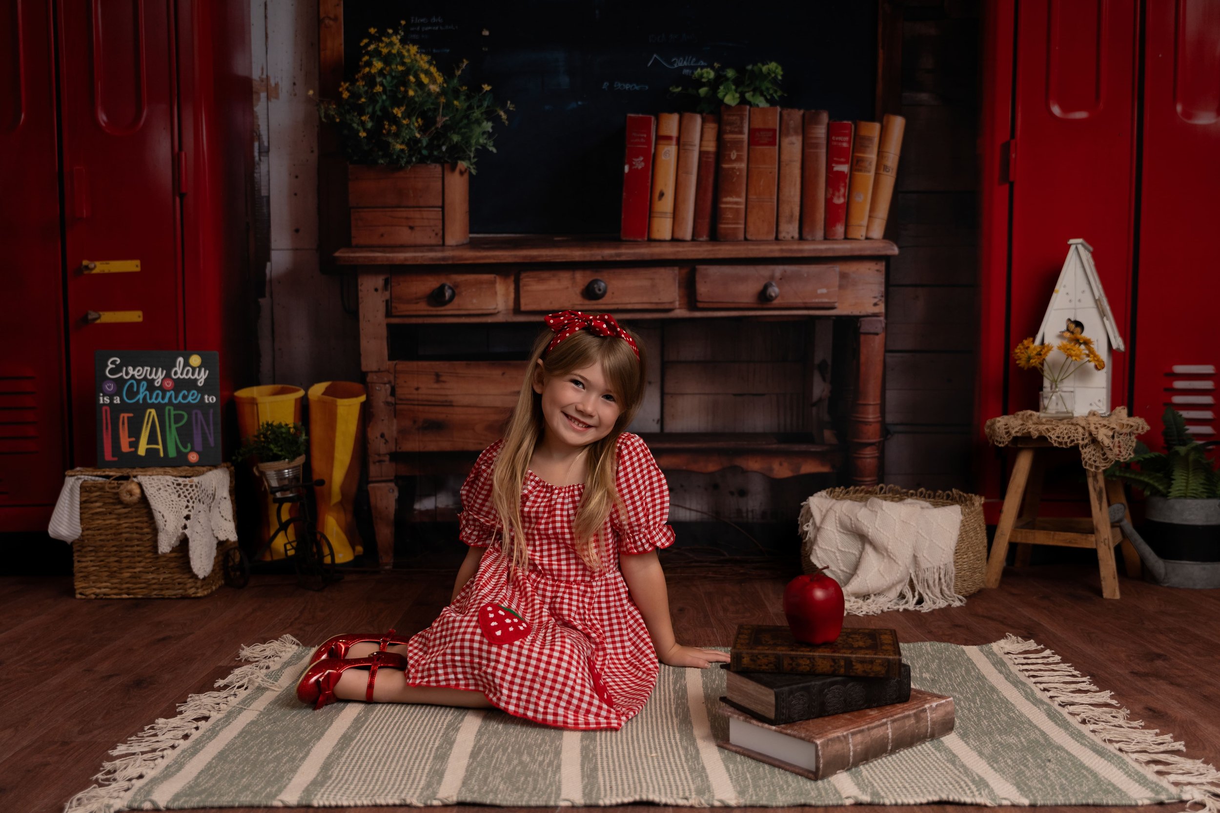 Studio setup for back to school minis sessions in Canton, GA by Captured Moments by Cindy featuring sweet little girl in polka dot red dress posing for back to school session