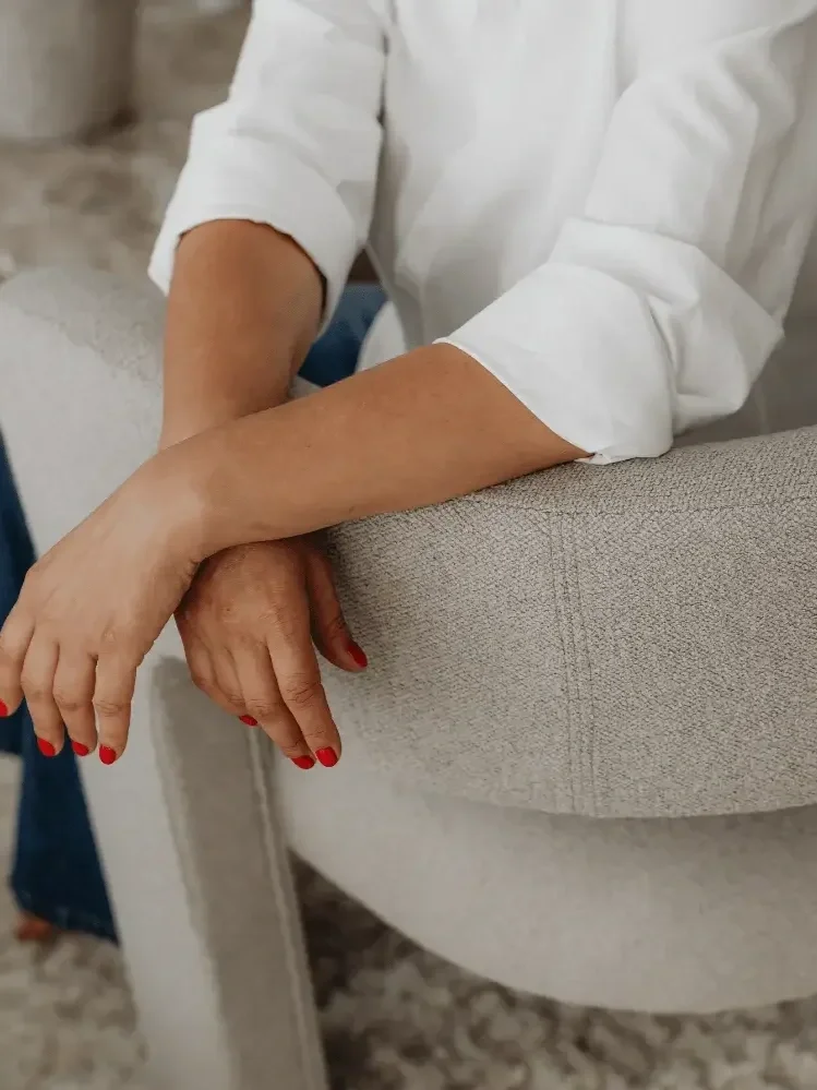 Professional seated with arms resting on chair, representing personalized bookkeeping support and consulting
