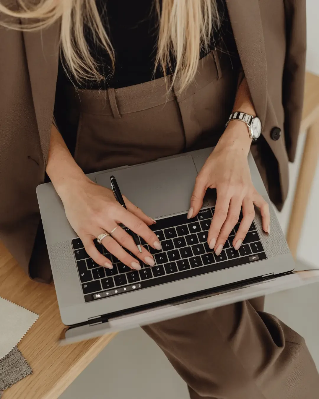 Accountant in brown suit working on a laptop, providing bookkeeping services