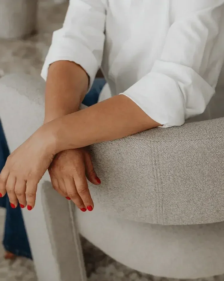 Professional seated with arms resting on chair, representing personalized bookkeeping support and consulting