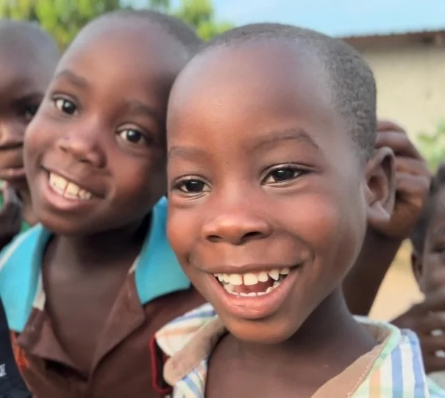 Group of smiling young children outdoors, close-up shot.