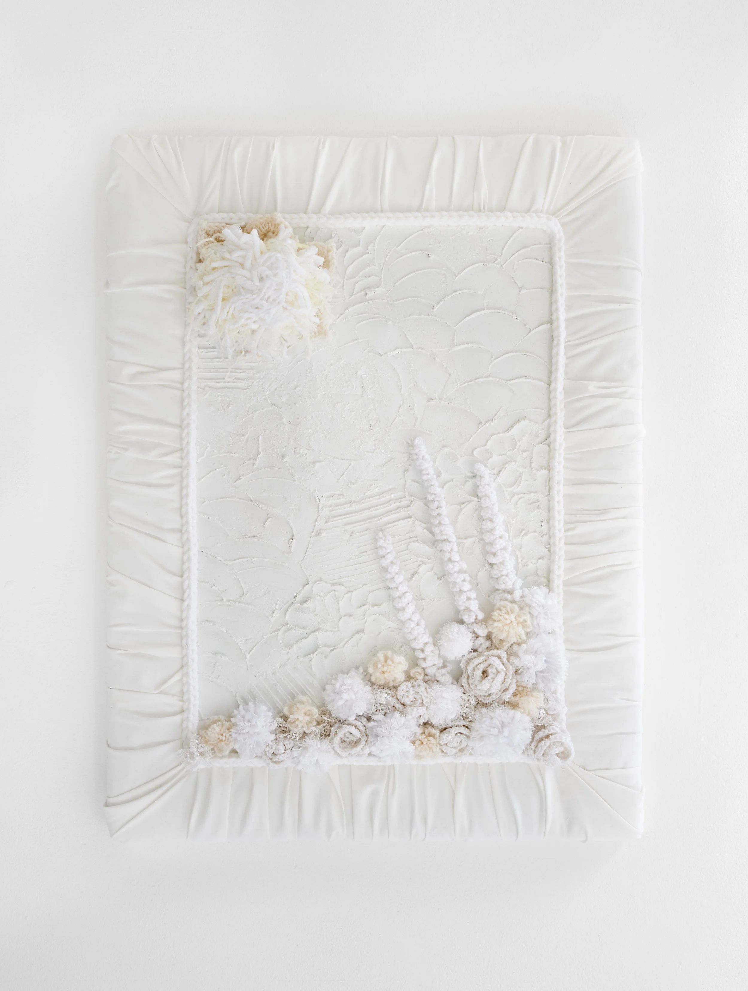From My Bed’ exhibition photograph of Mandy Shepherd's ‘From My Bedroom Window’ against a white wall in the gallery. The artwork is a white A2 sized mixed media artwork. The canvas background is covered with plaster of Paris using a palette knife cre