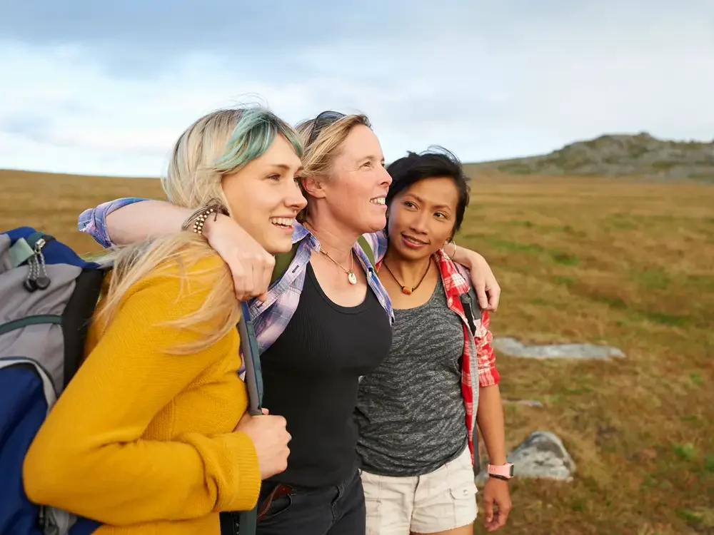 3 friends hugging while hiking