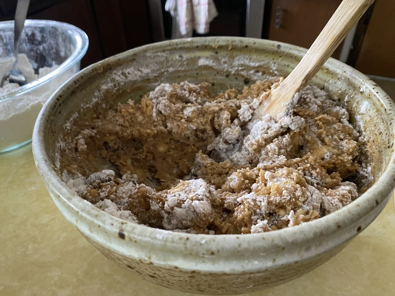 cookie dough batter halfway through mixing with a wooden spoon
