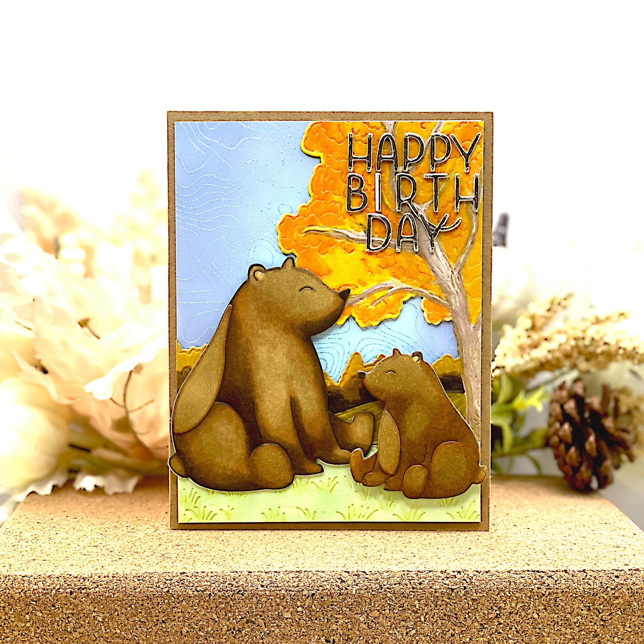 Birthday card with mama bear and bear cub in autumnal landscape