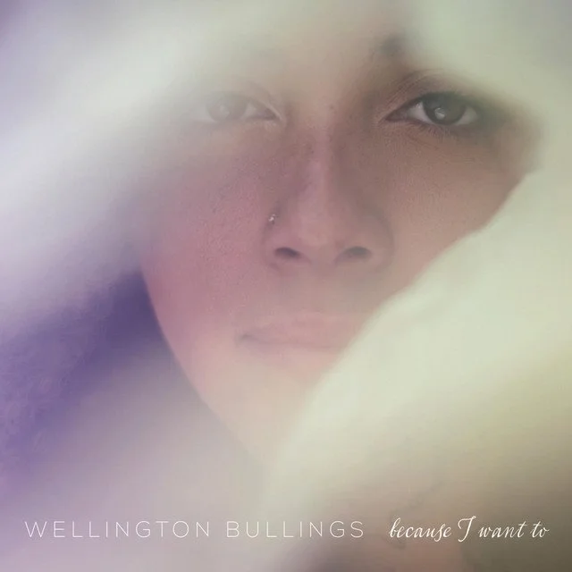 Close-up of a person's face with a nose piercing, partially covered by a soft, blurred foreground. Text overlay reads 'Wellington Bullings because I want to'.