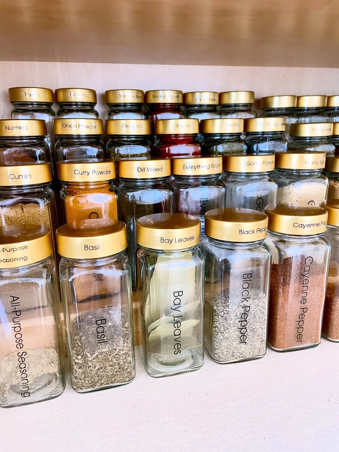 Details, details, details! We love tiered shelving for spices, but it can be difficult to see the labels on jars. 

Our solution? Adding custom labels to the lid edges so this client can easily see exactly what she has. Beauty and functionality all i
