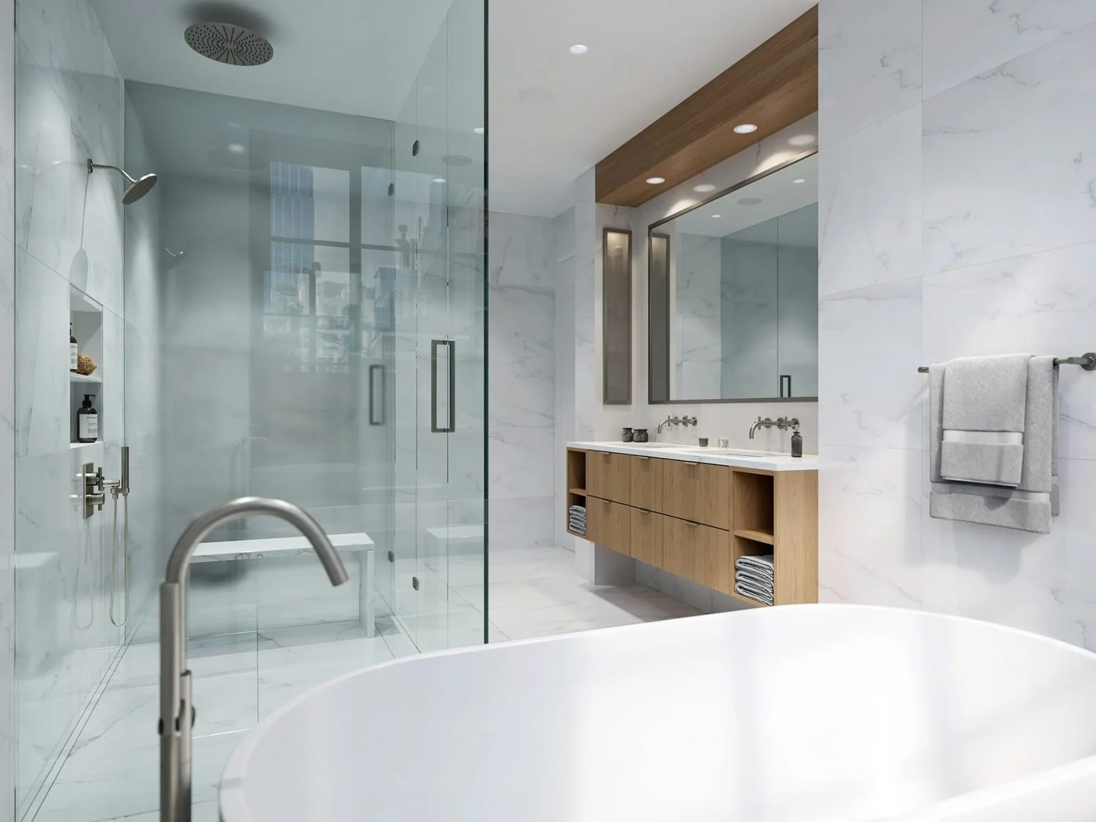 Modern bathroom with a white freestanding tub, a glass-enclosed shower, a double sink vanity with a large mirror, and white marble walls.