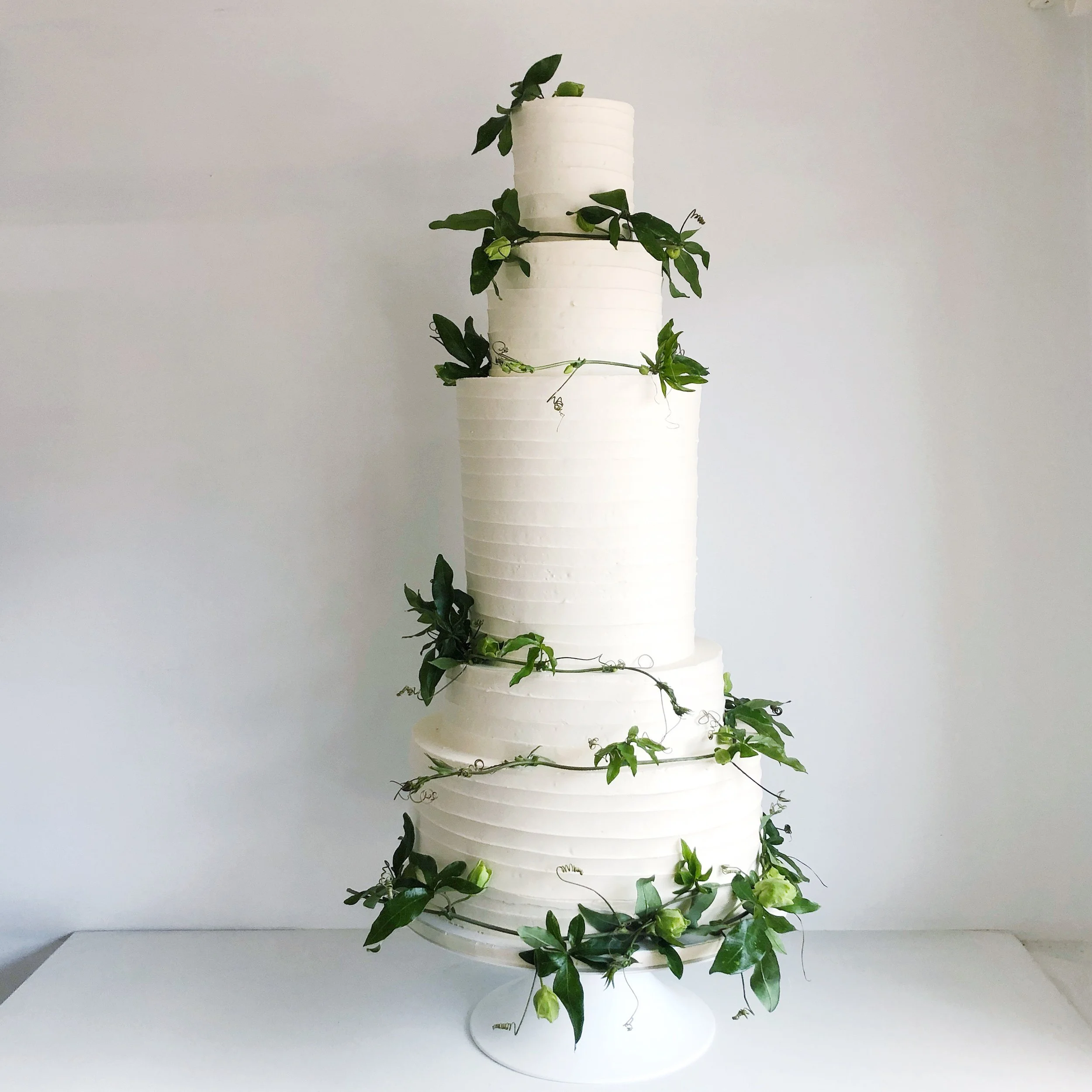 Extra tall pallet knife buttercream design with greenery