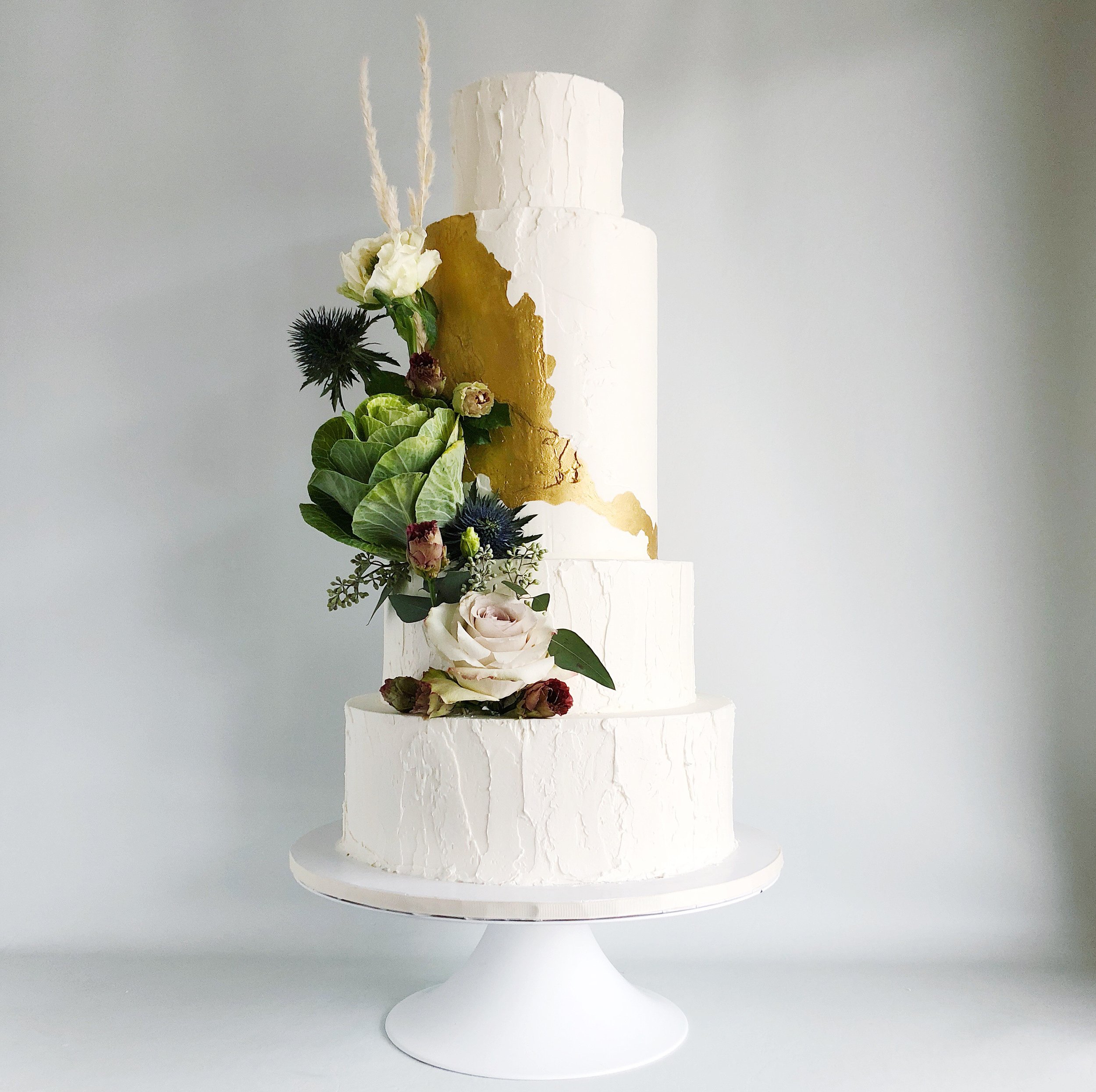 Extra tall textured buttercream with gold leaf abstract design and fresh flowers