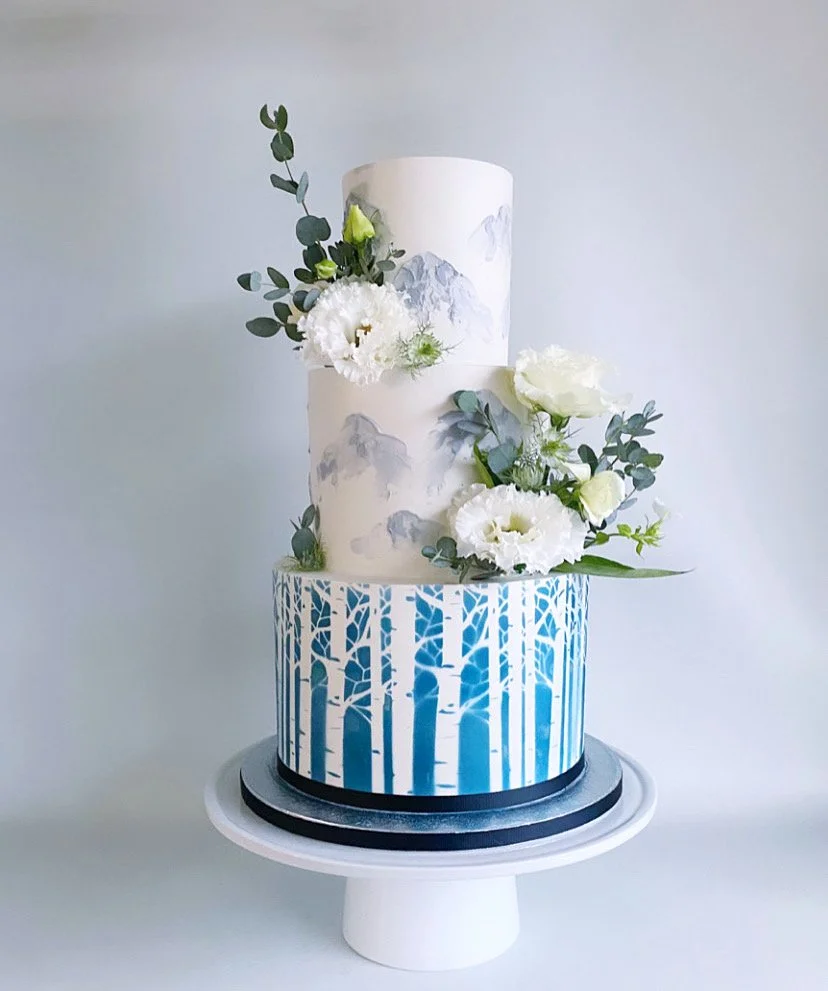 Coloured buttercream mountains with air-brushed birch trees and fresh flowers
