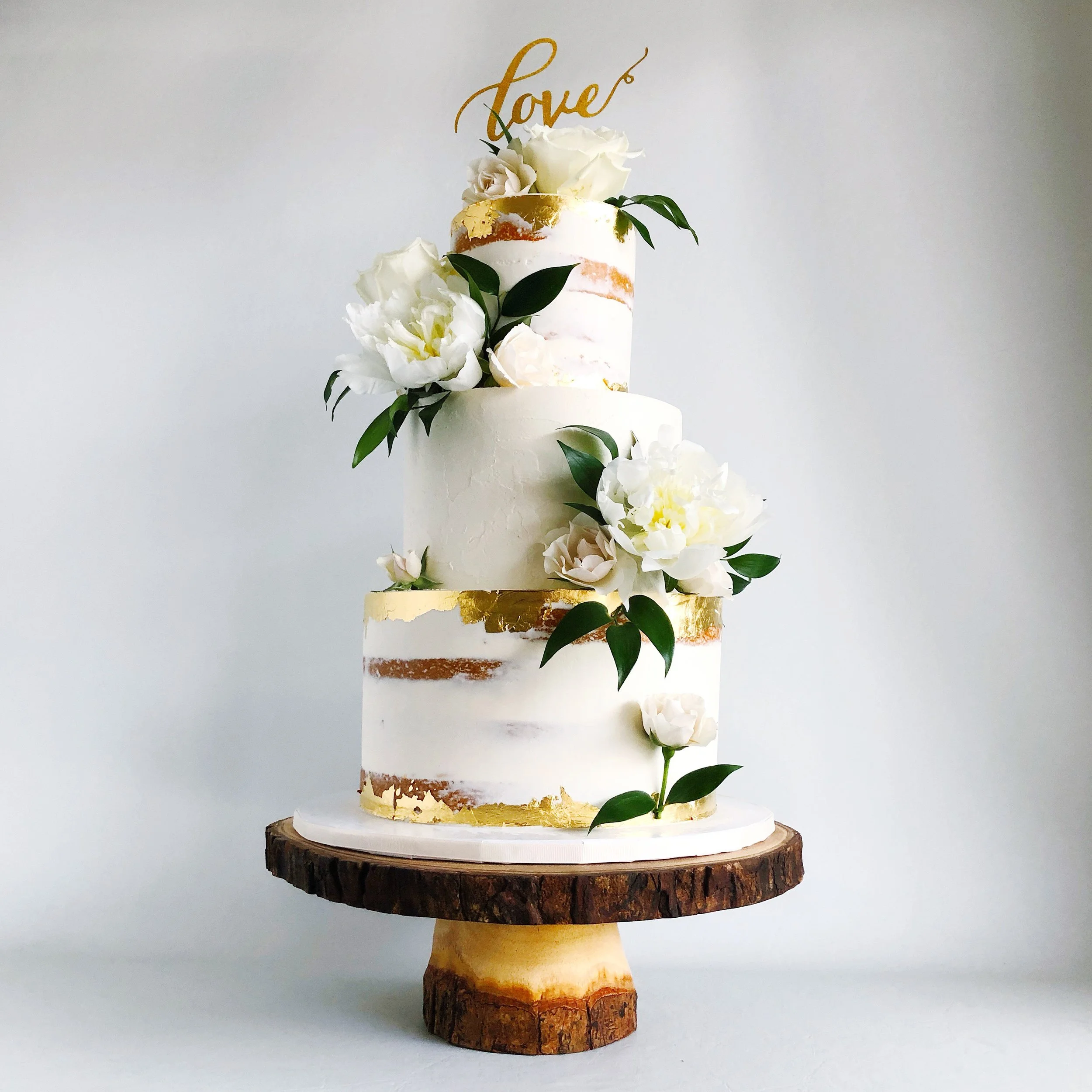 Semi-naked design with gold leaf caps and fresh flowers