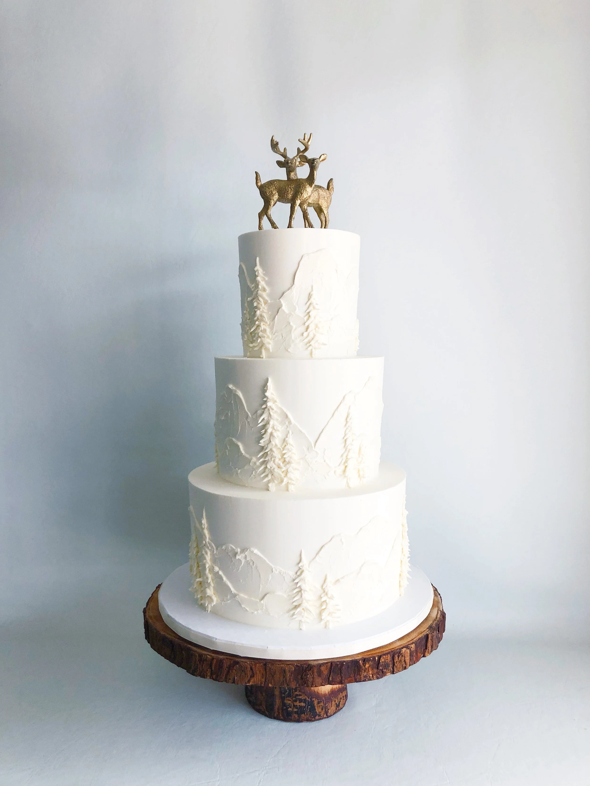 White buttercream mountains + trees design