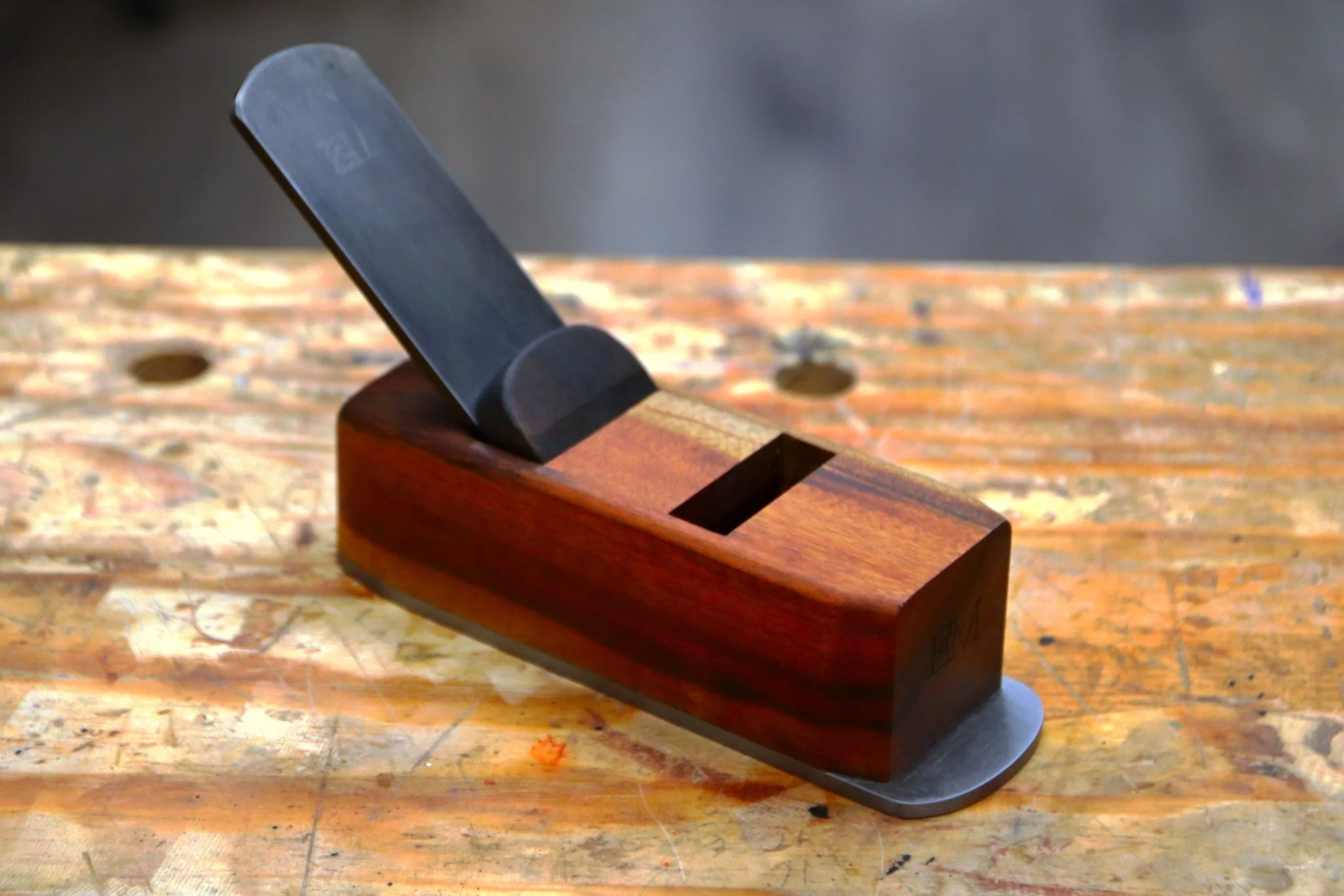 Block plane made from goncalo alves wood sitting on a work bench