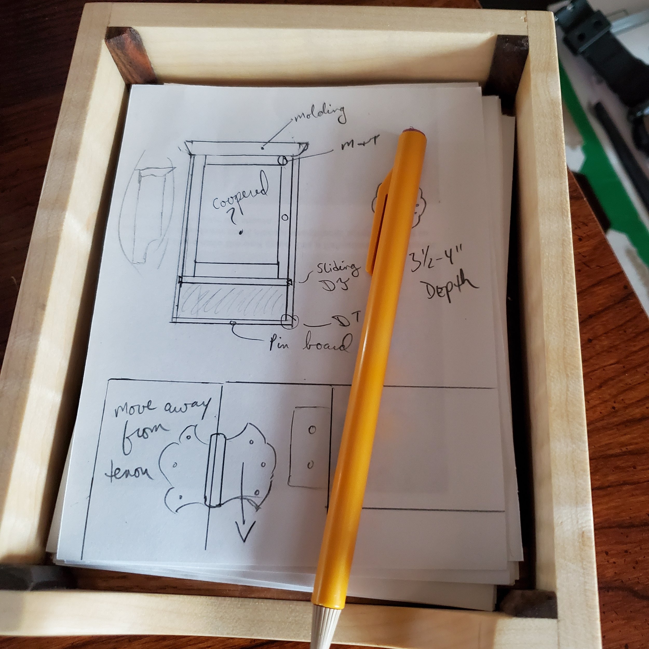 Paper tray filled with paper and a pencil sitting on a desk.