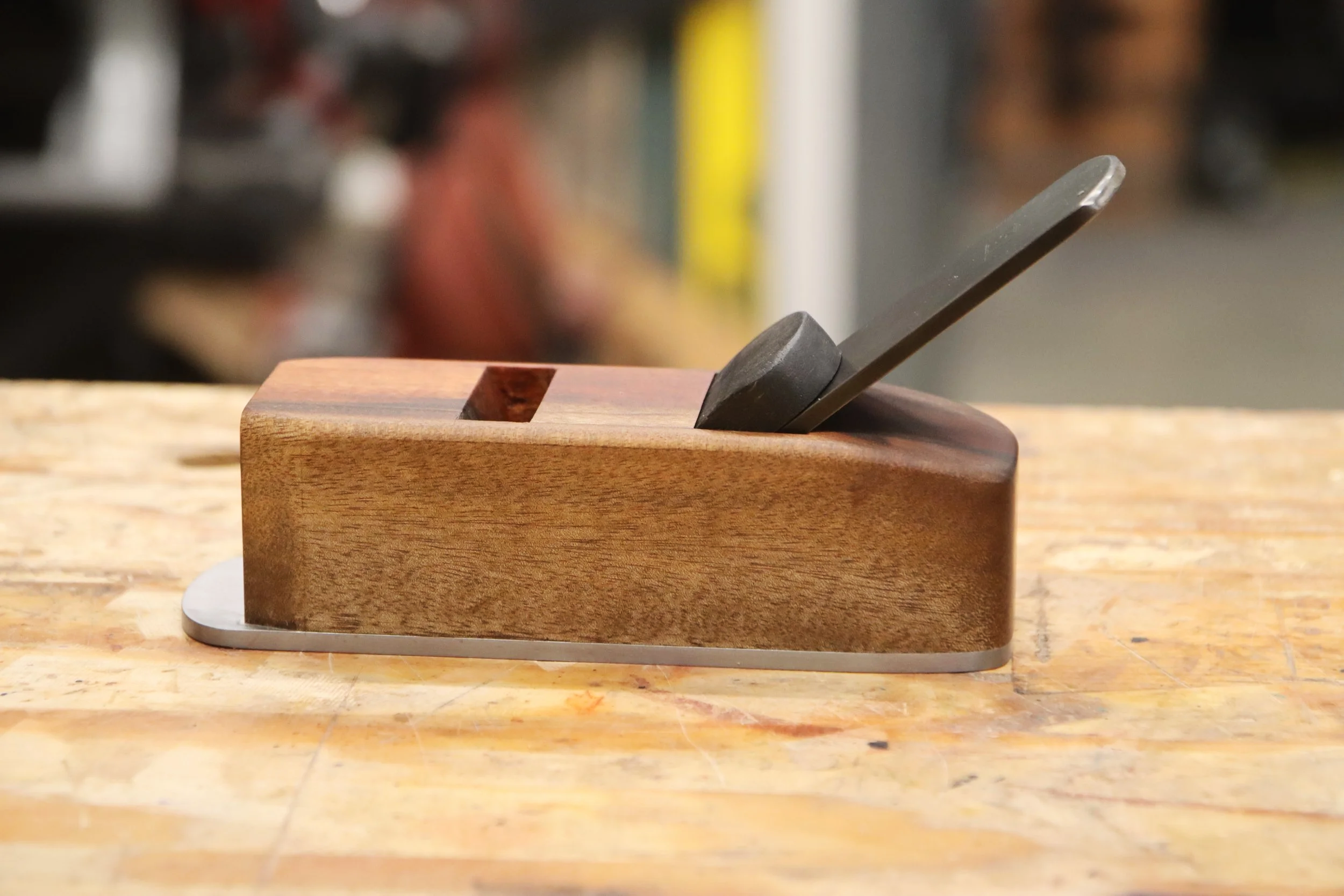 Block plane made from goncalo alves wood sitting on a work bench