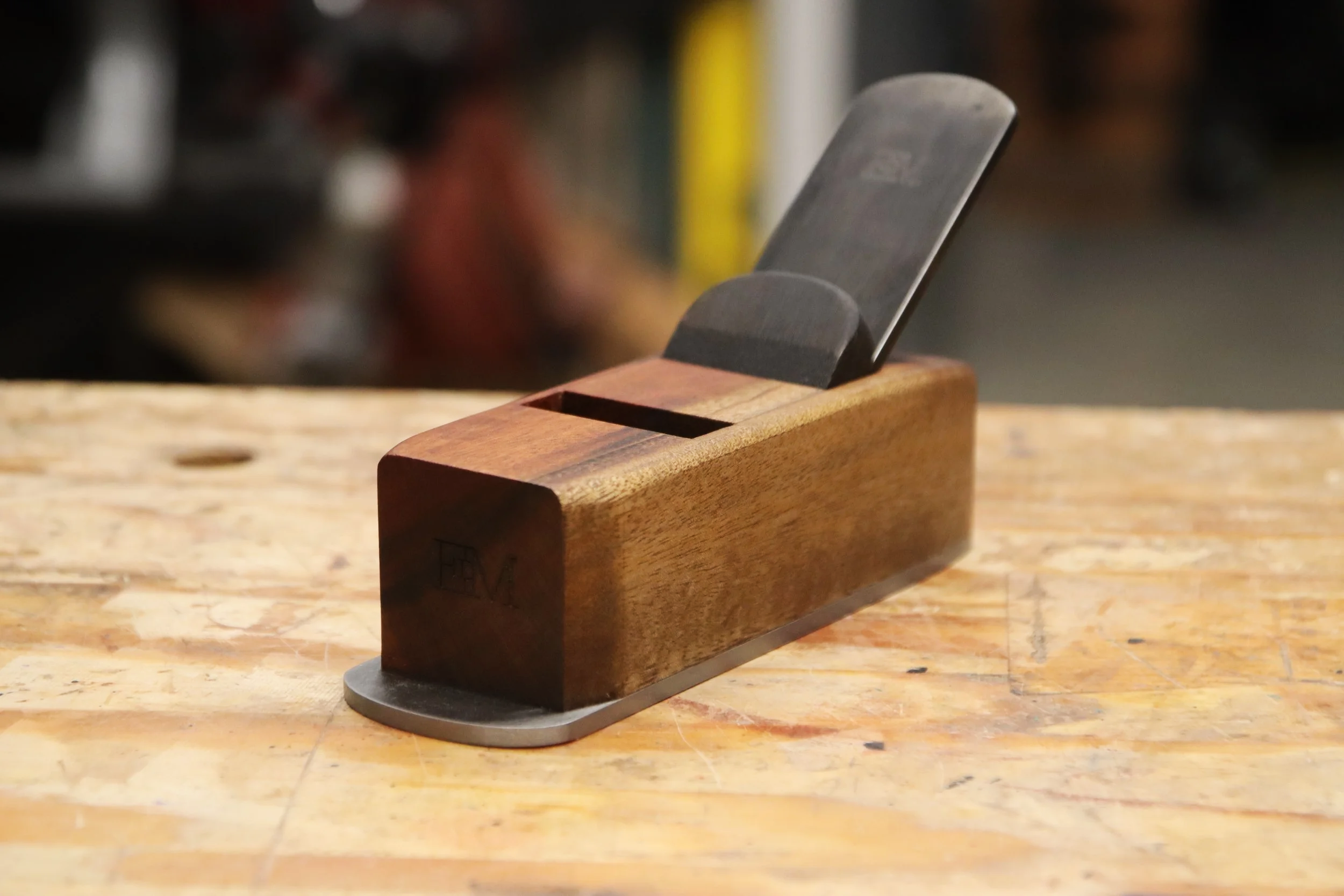 Block plane made from goncalo alves wood sitting on a work bench
