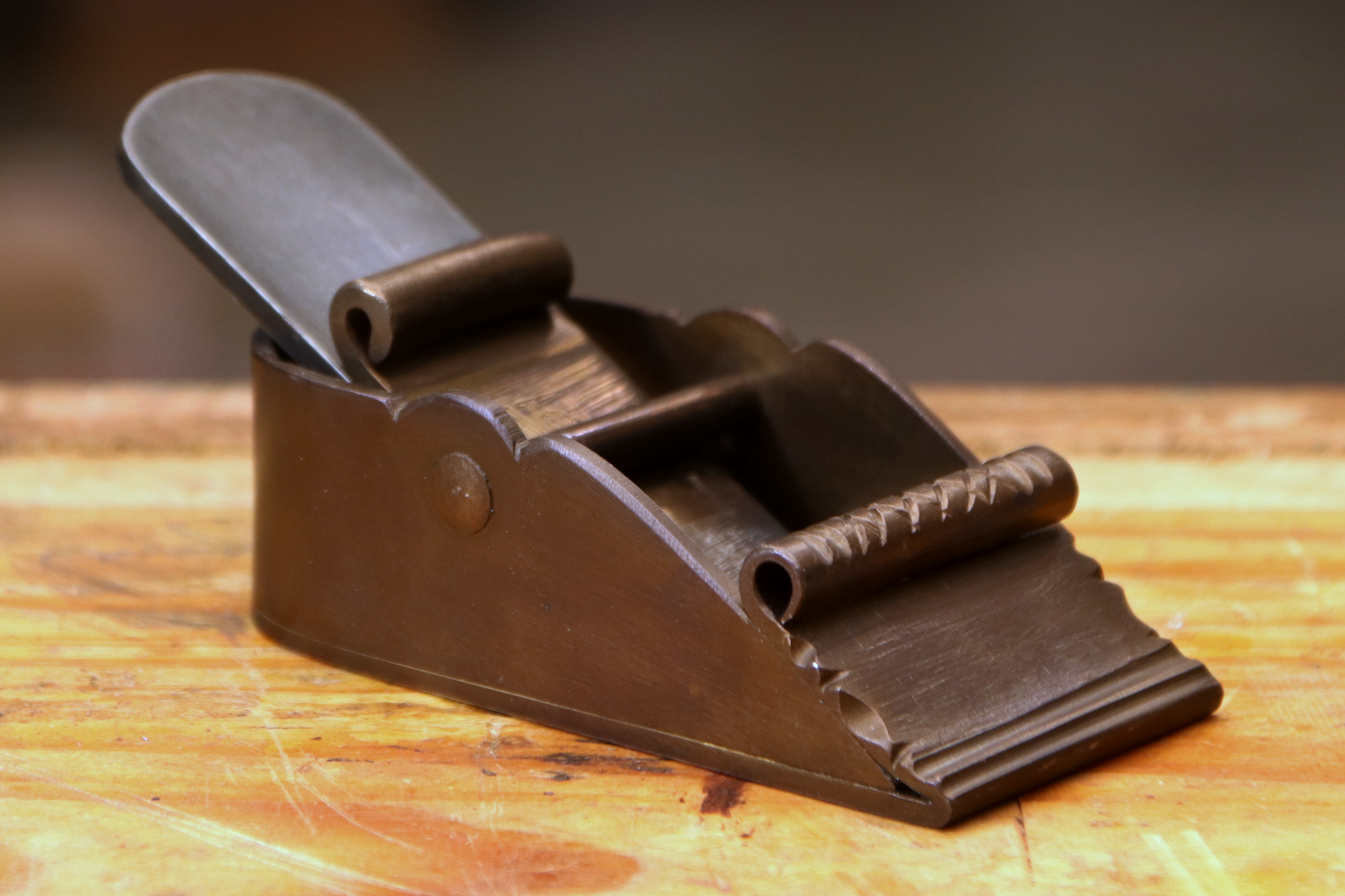 Photo of a forged hand plane sitting on a workbench