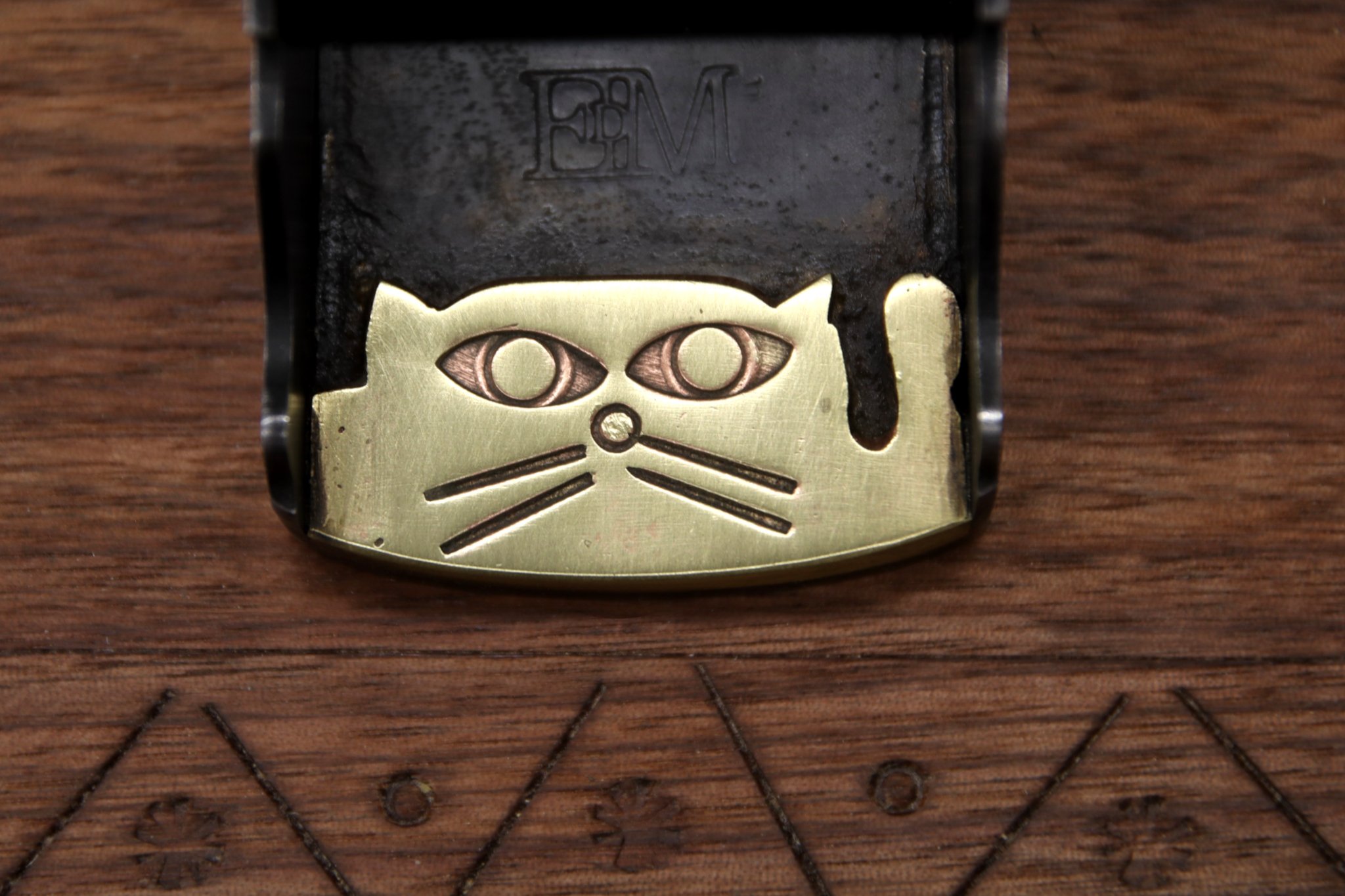 Cat face made of brass that has been brazed inside of the plane's body
