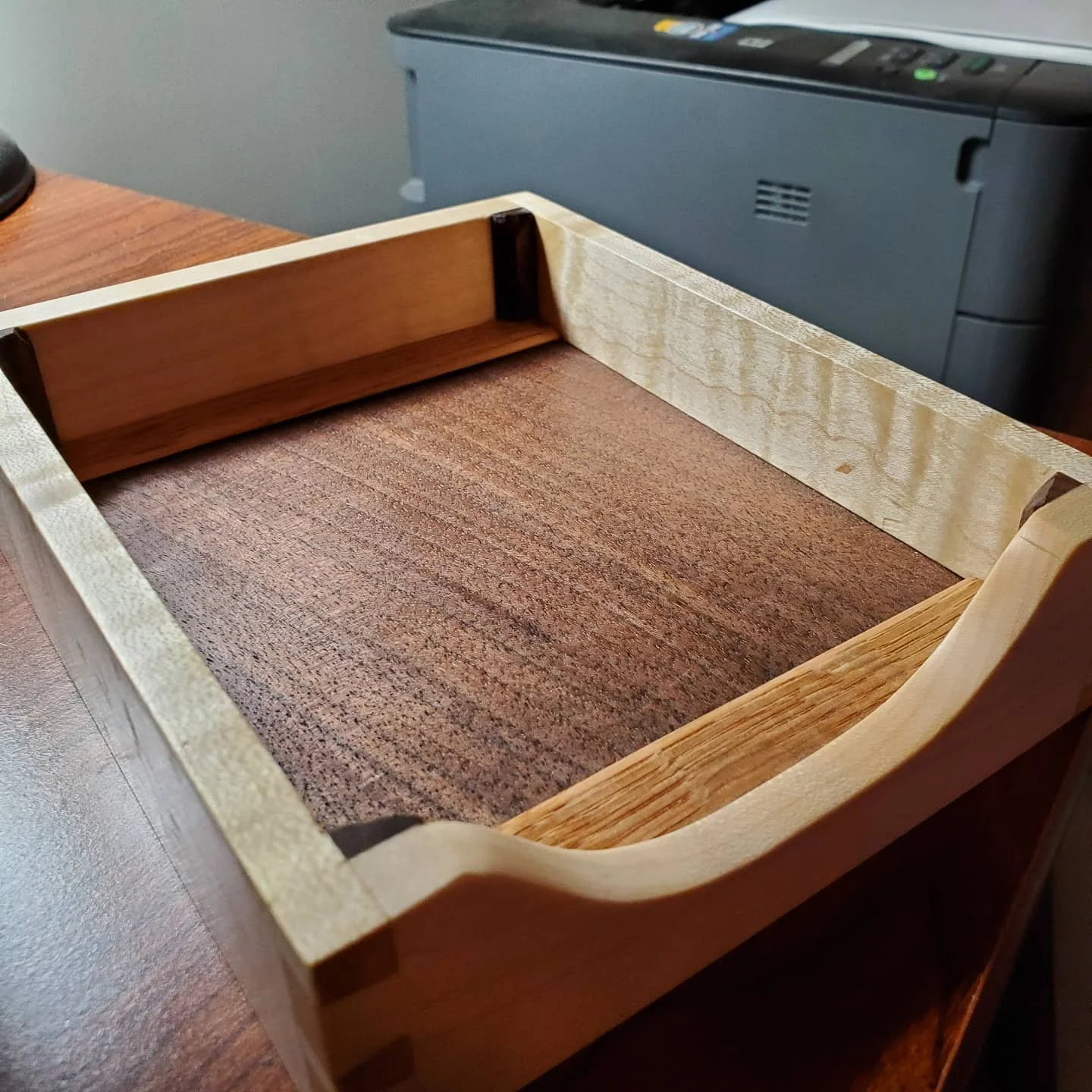Empty paper tray showing the walnut bottom. 