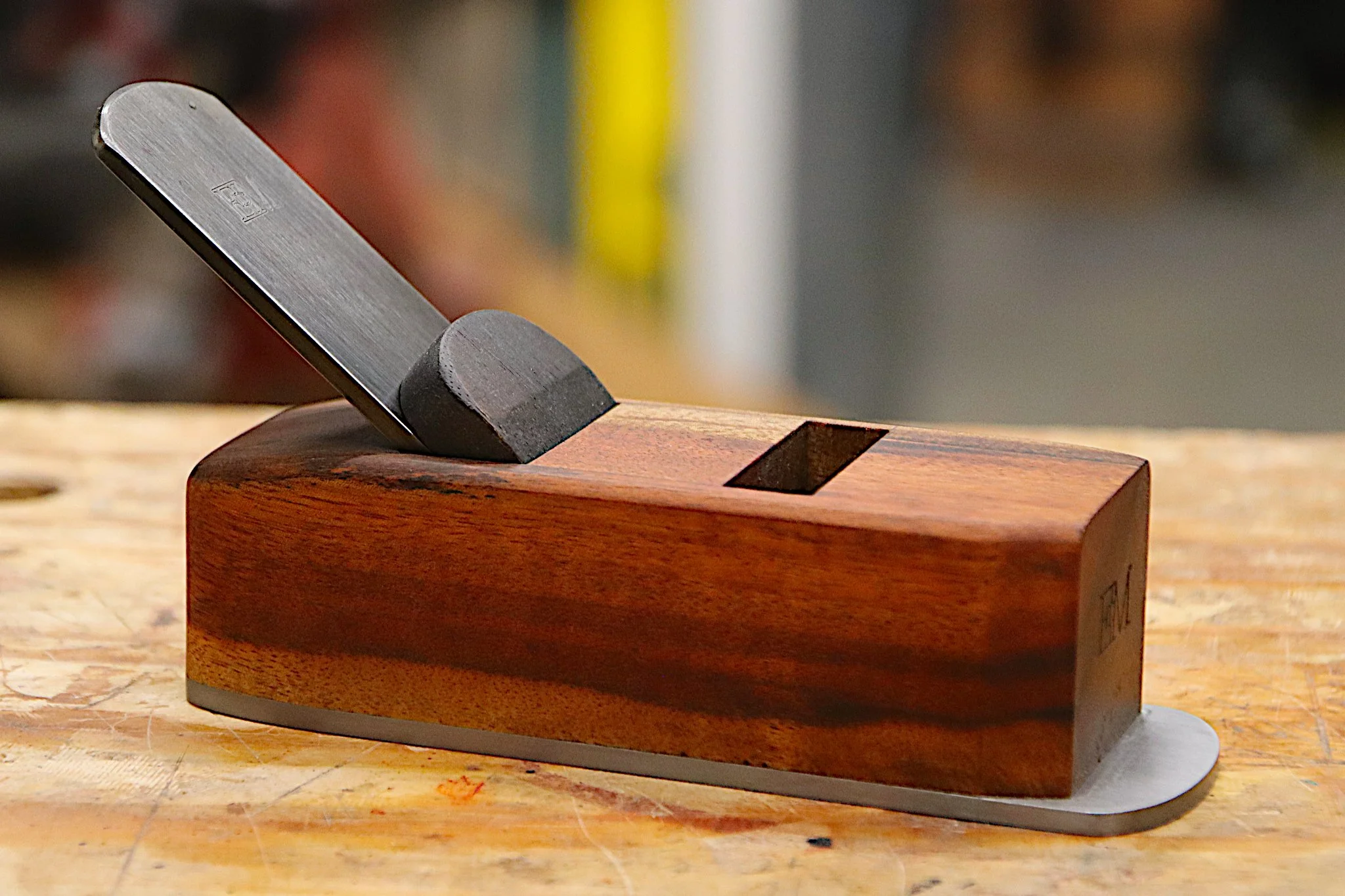 Block plane made from goncalo alves wood sitting on a work bench