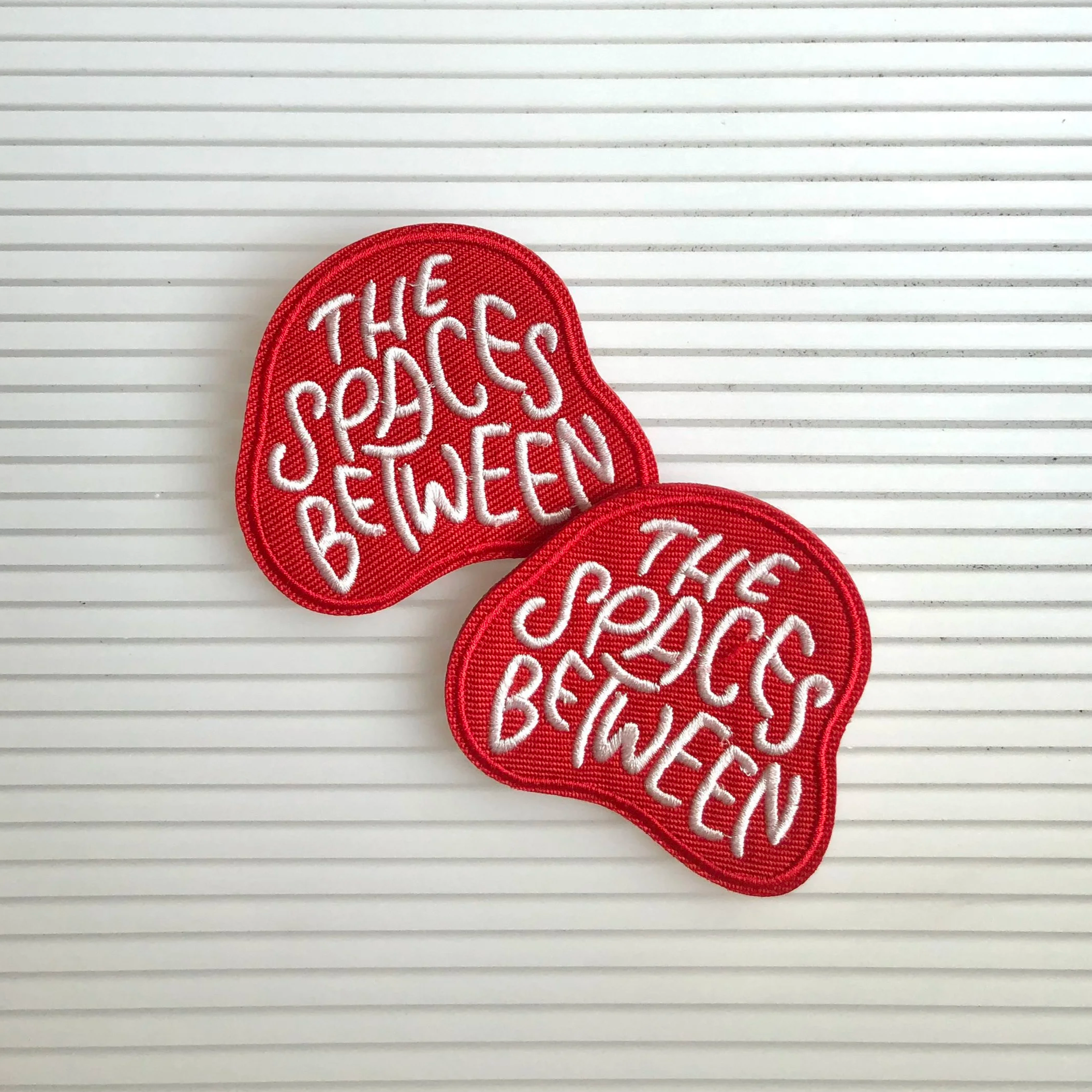 The Spaces Between Badge