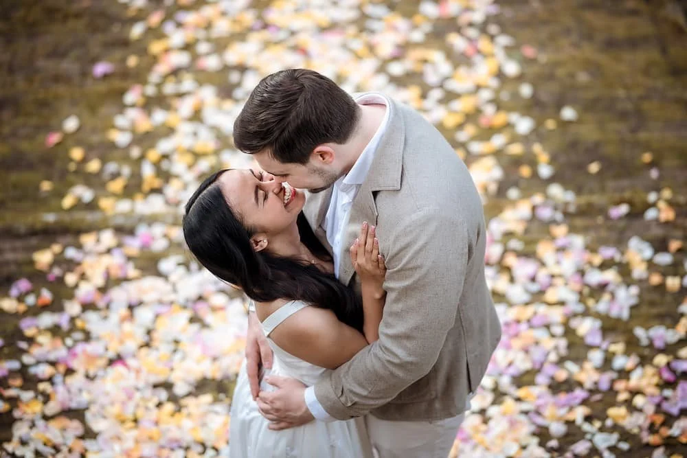 Happy couple smiling on a carpet of colorful petals