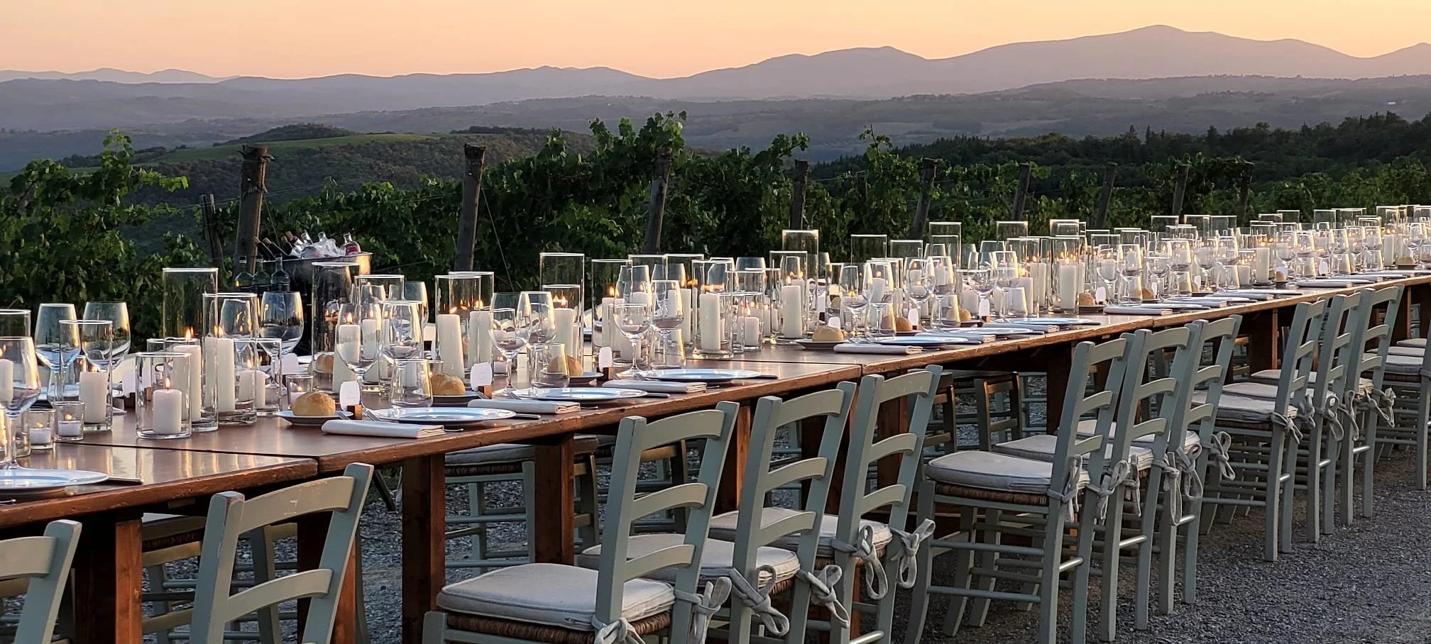 Elegant candle lit table facing the vineyards at sunset in the midsts of the beautiful Tuscan landscapes
