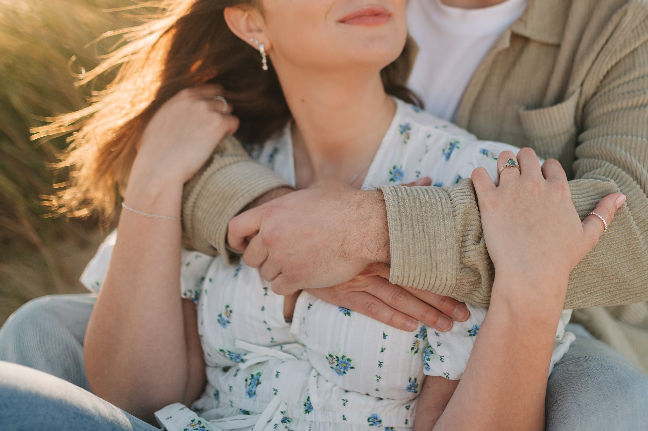 Norfolk Wedding Photographer.  Close-up of a woman and child hugging outdoors during sunset, with the woman holding the child's head and the child's arms around her.
