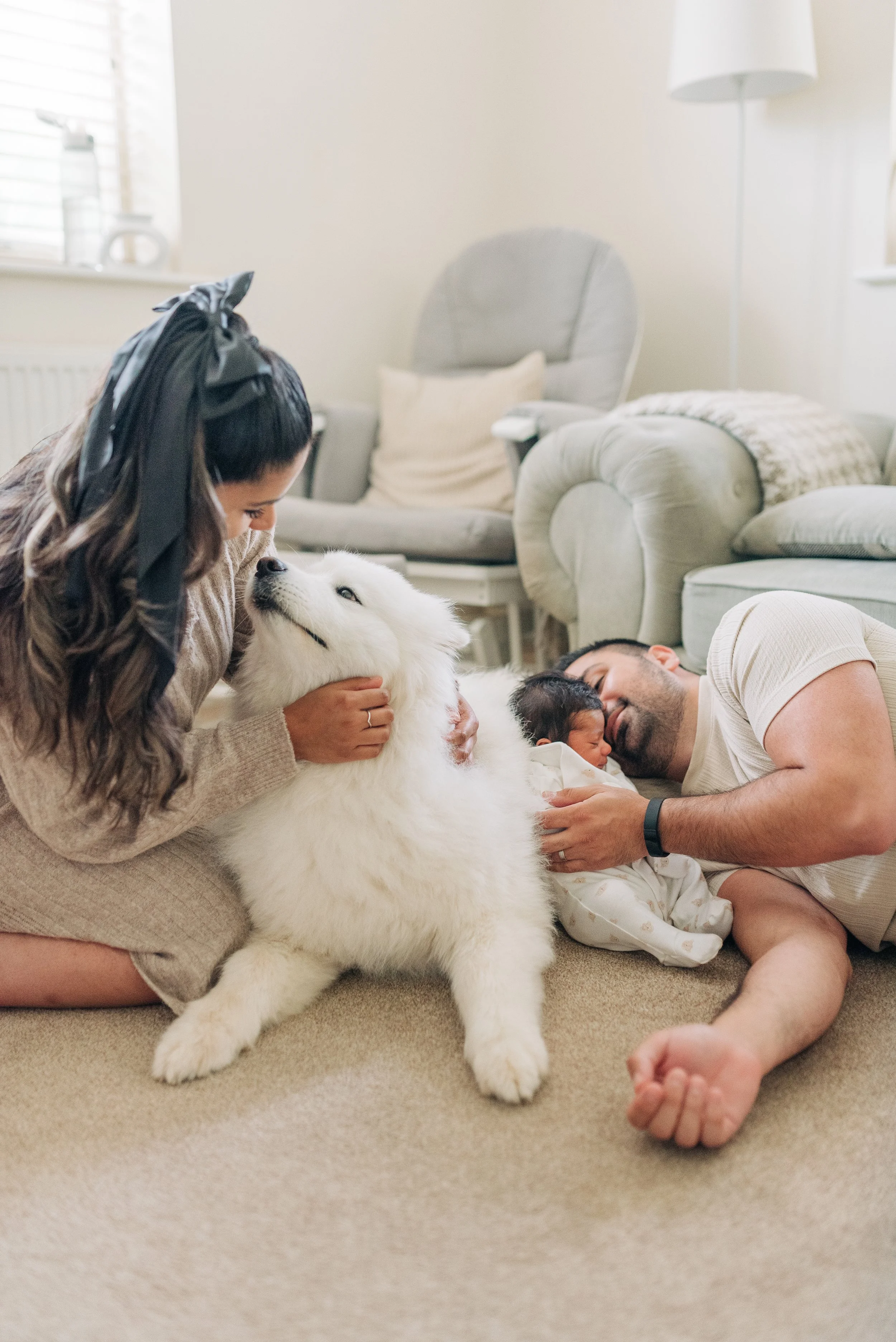 Norfolk Family Photographer. Family on the floor with a dog and newborn baby in a cozy living room.