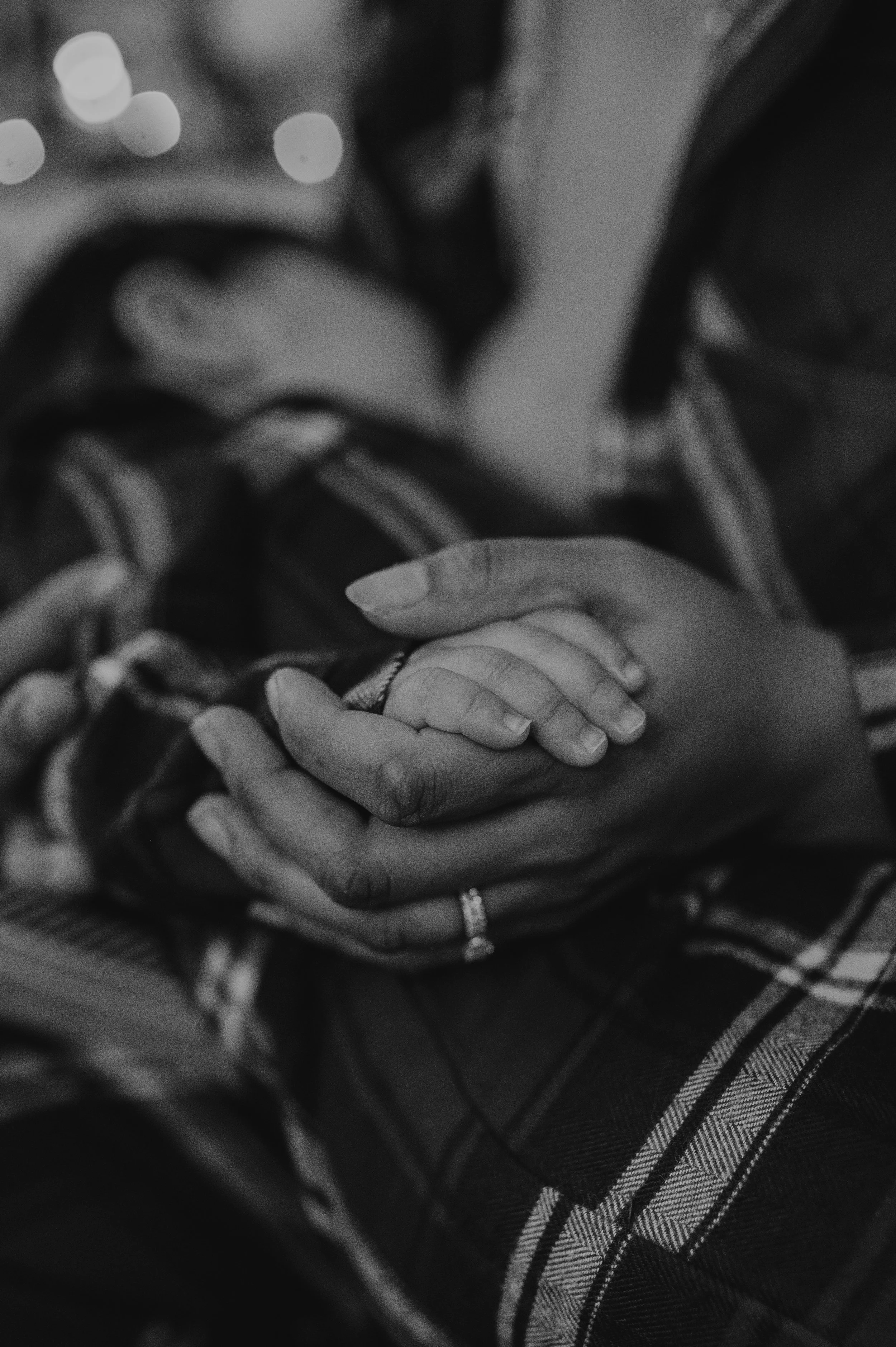 Norfolk Family Photographer.  Close-up of an adult's and child's hands holding each other, black and white photo.