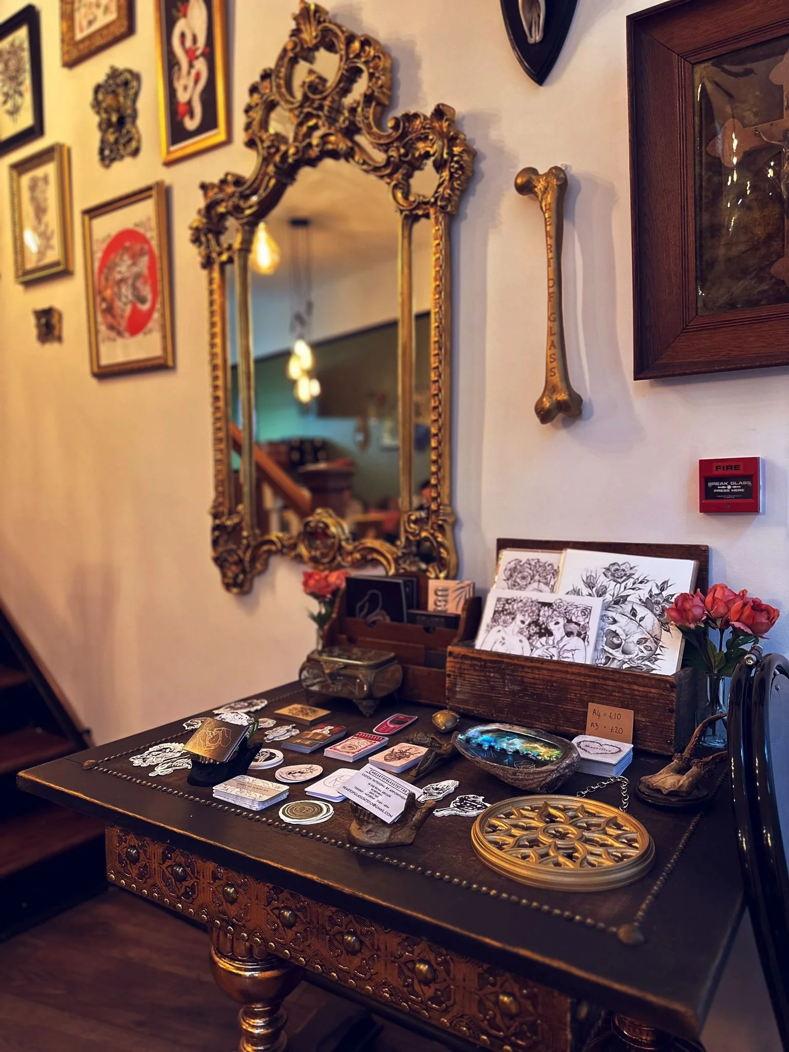 Sticker display and ornamental mirror at Heart of Glass Tattoo studio