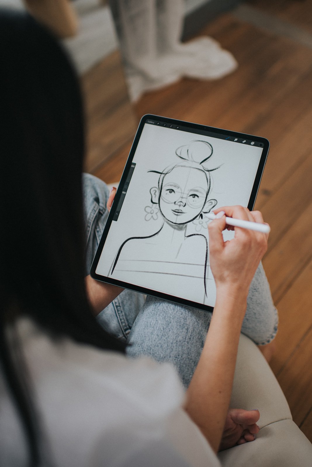 Person using a digital tablet to draw a portrait sketch.