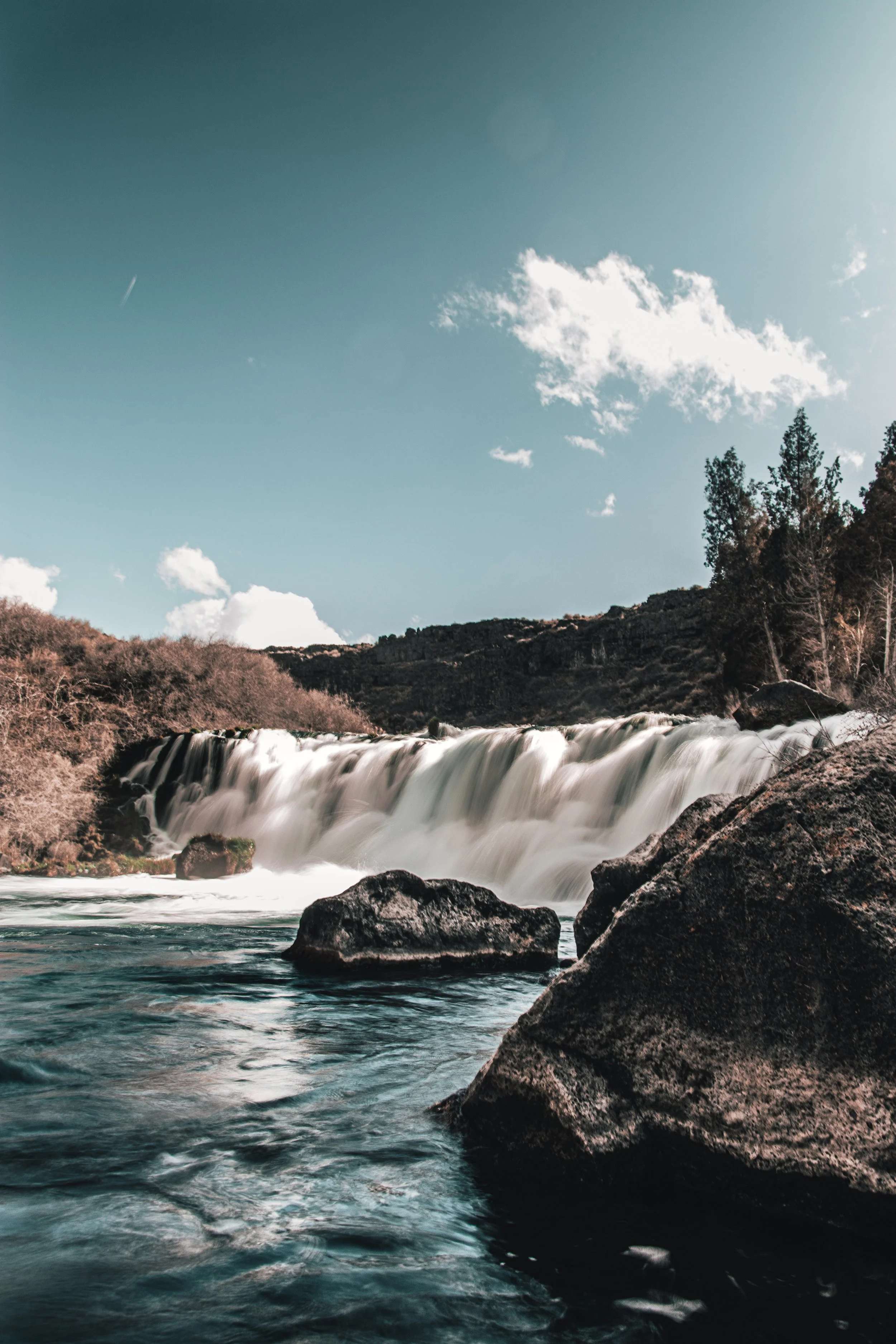 Scenic waterfall with rocks and blue sky