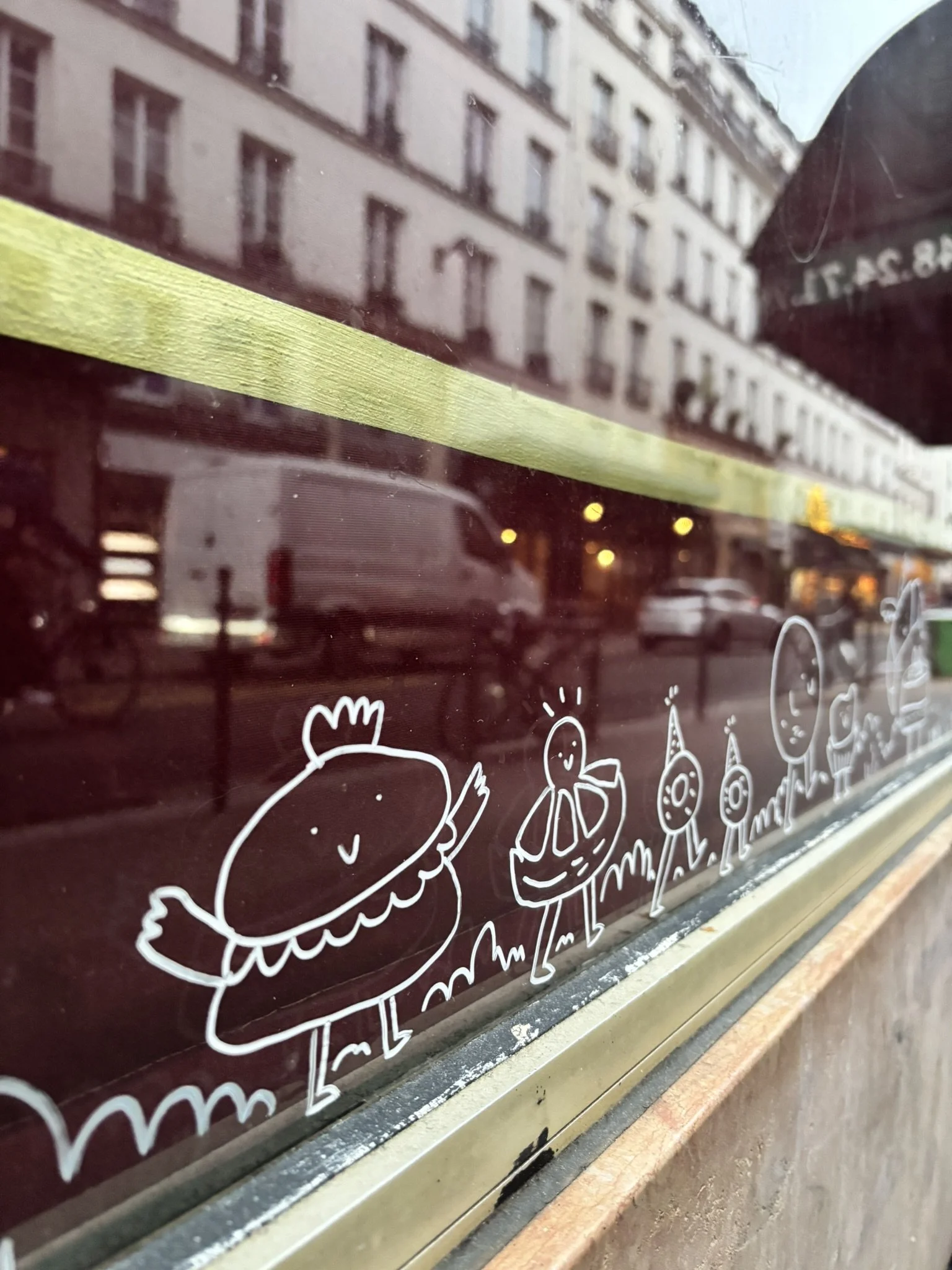 Glass with illustrations of cute sketchy figures in an urban street setting.